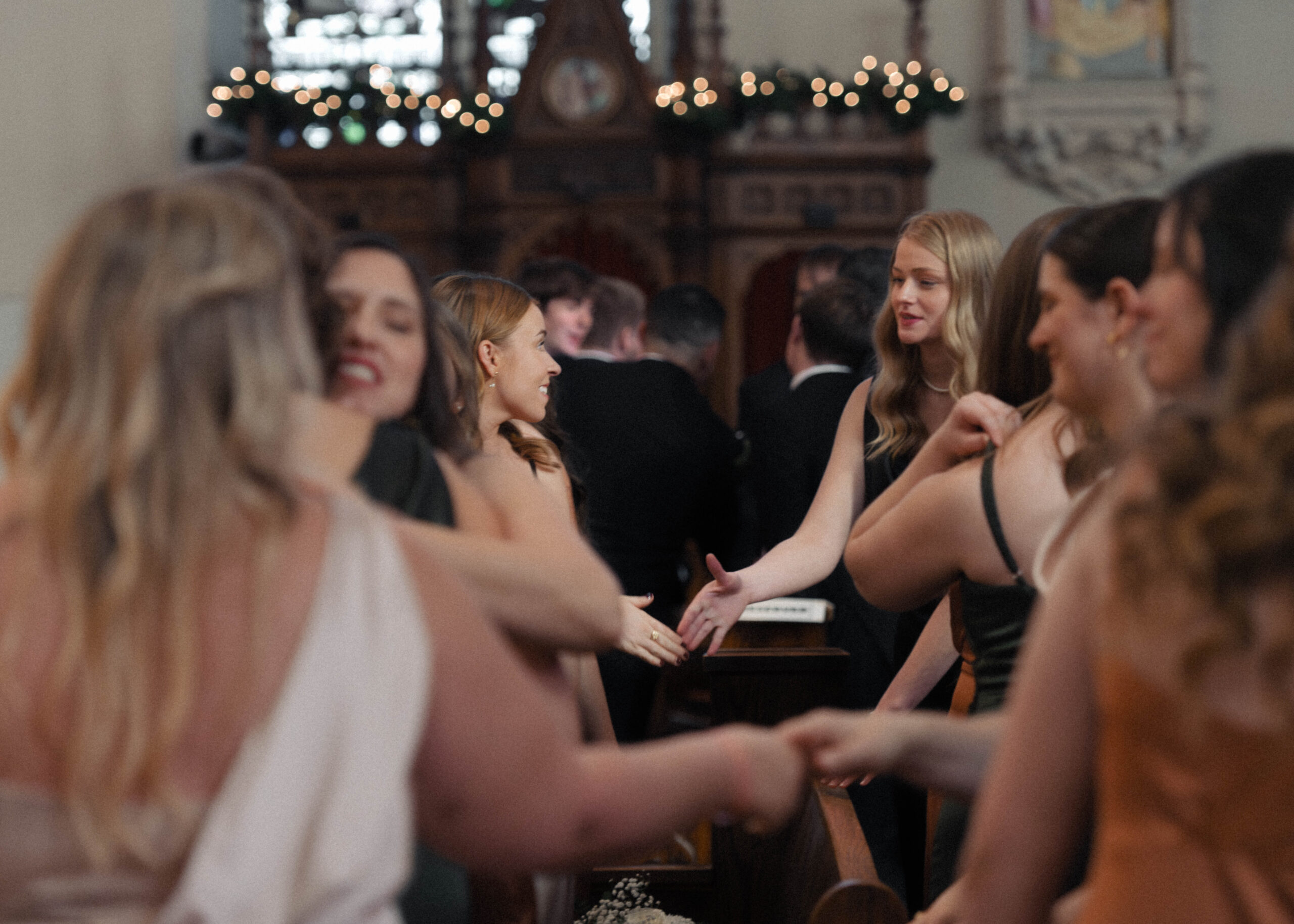 Bridesmaids shake hands during a nuptial Mass.