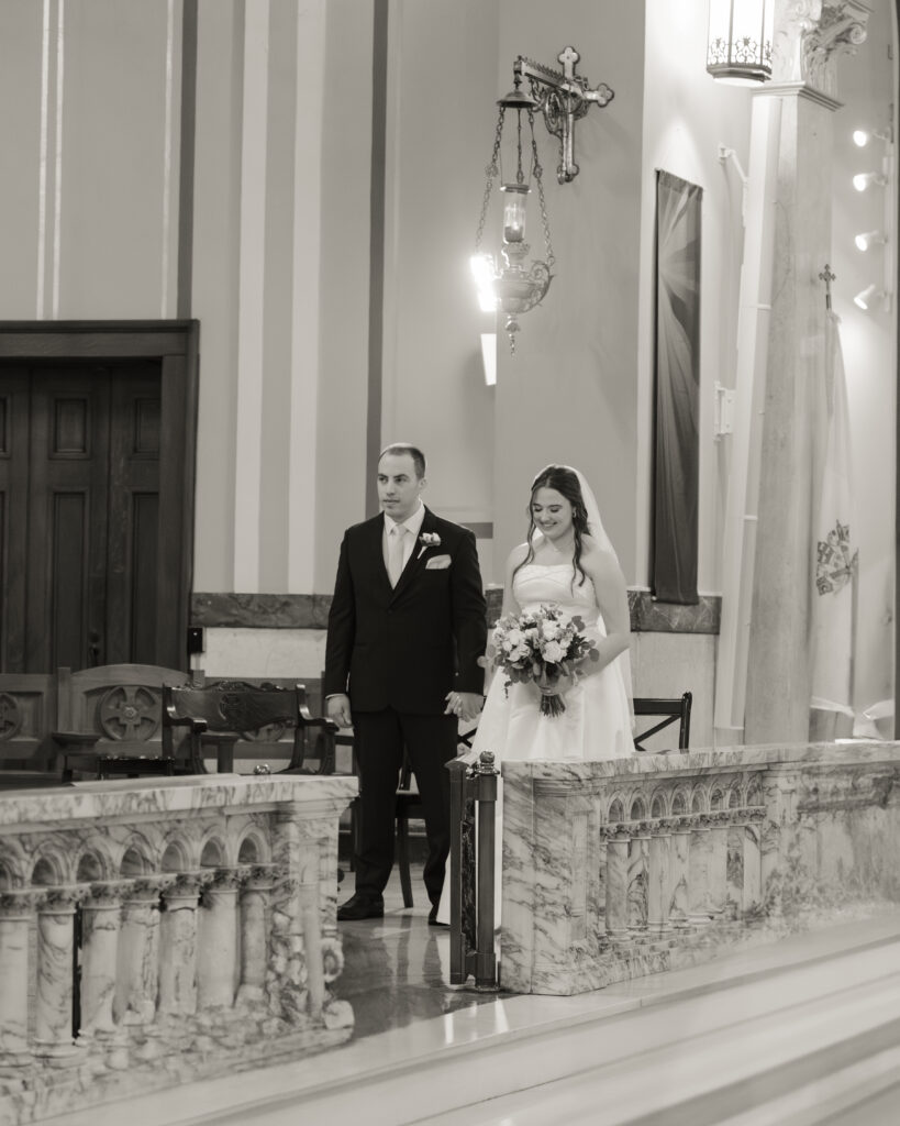 A bride and groom stand during the readings at their catholic wedding ceremony at Our Lady of the Rosary in Dayton, Ohio.
