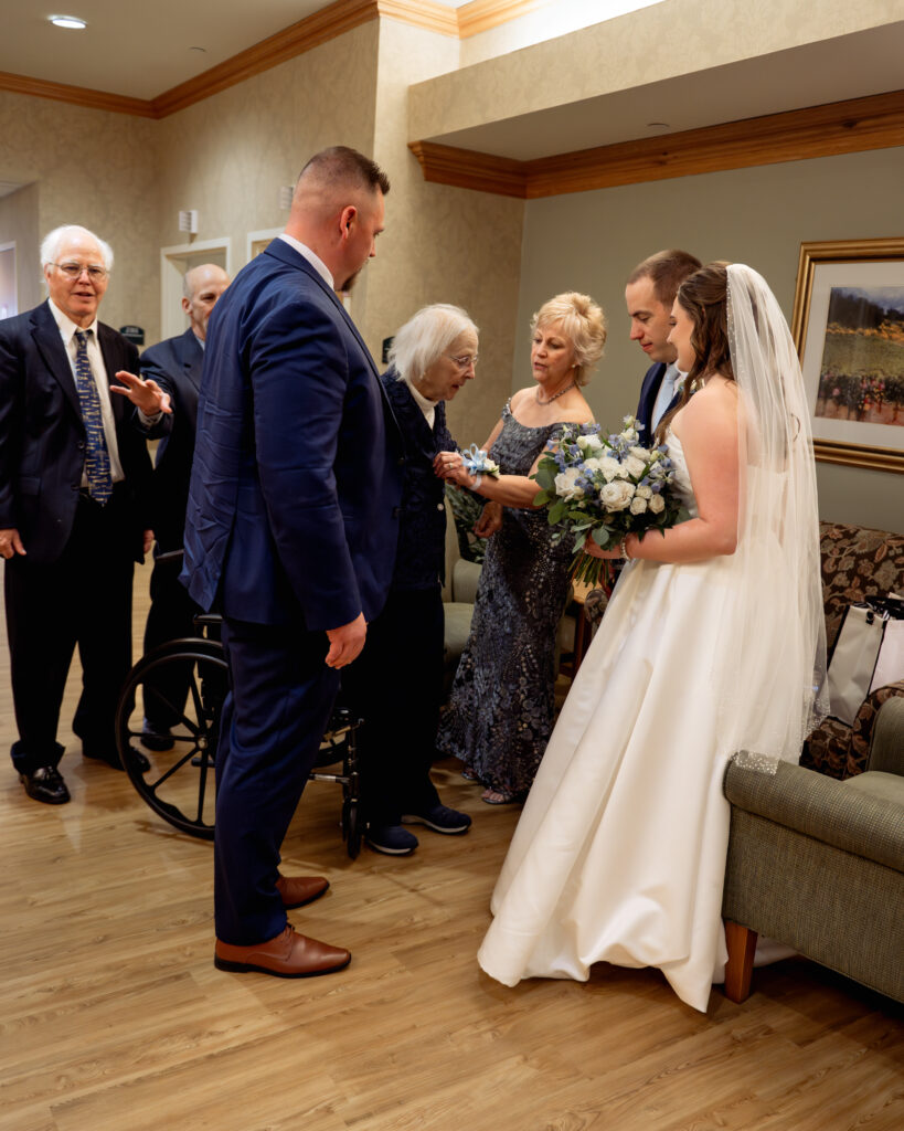 A catholic bride and groom visit with the grooms grandmother at a nursing home following their catholic wedding ceremony in Dayton, Ohio