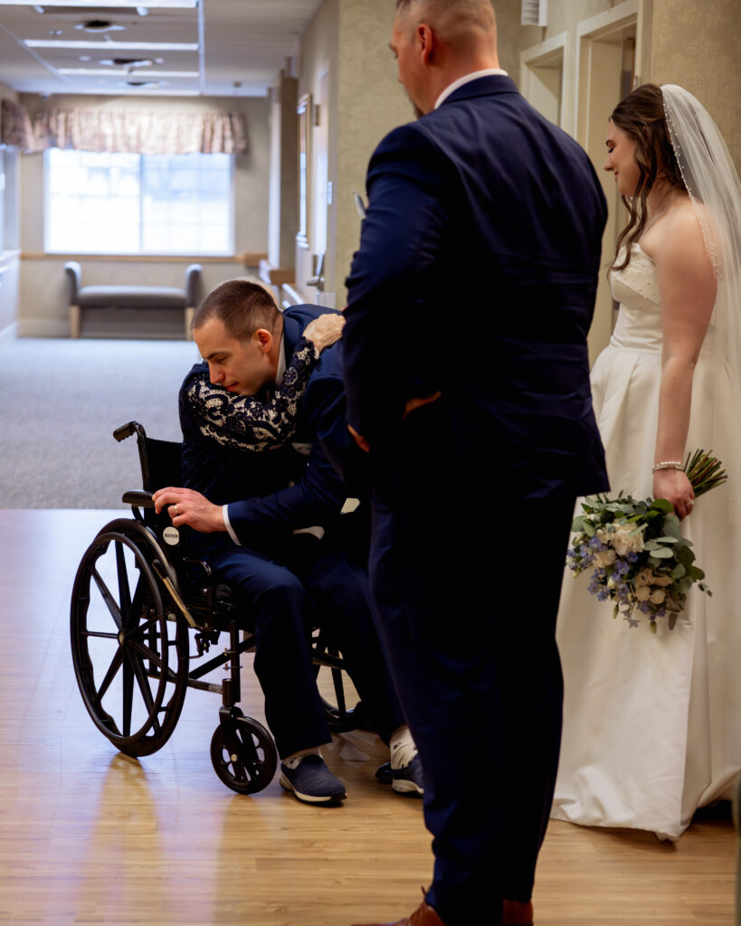 A catholic bride and groom visit with the grooms grandmother at a nursing home following their catholic wedding ceremony in Dayton, Ohio. The groom gives his grandmother a hug.