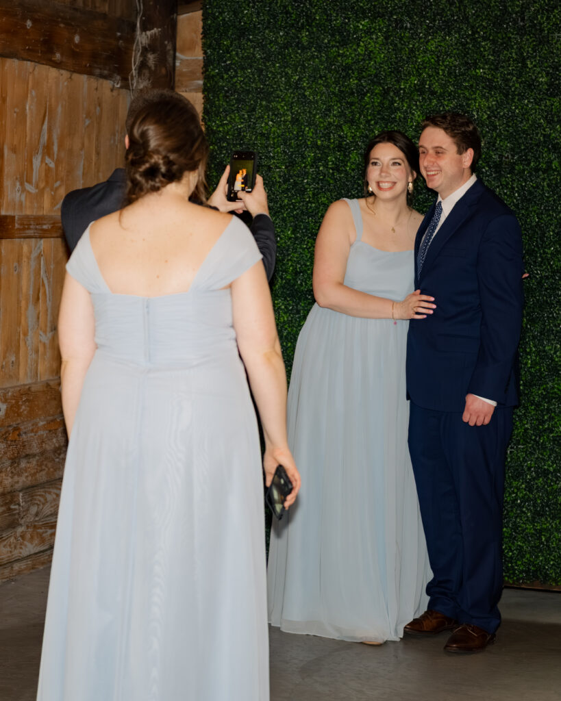 Guests take photos at a photo backdrop during a wedding reception in Piqua, Ohio.