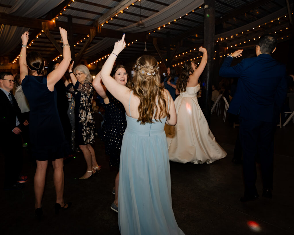 Guests all dance with their hands in the air during a catholic wedding reception in Piqua, Ohio.