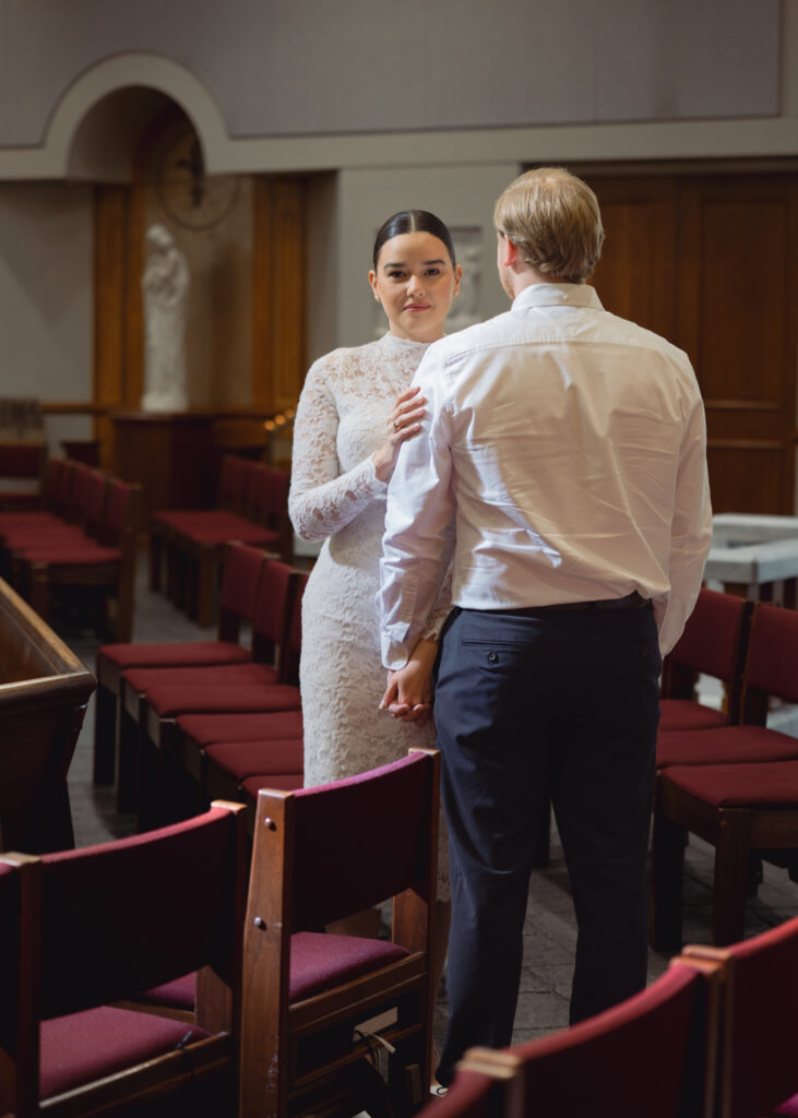 A couple poses inside St. Mary's Catholic church in Jackson, Tennessee during their sunny engagement session ahead of their catholic wedding.
