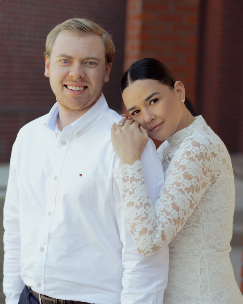 A catholic engaged couple looks at the camera and poses for a portrait during their engagement session at St. Mary's Catholic Church in Jackson, Tennessee.