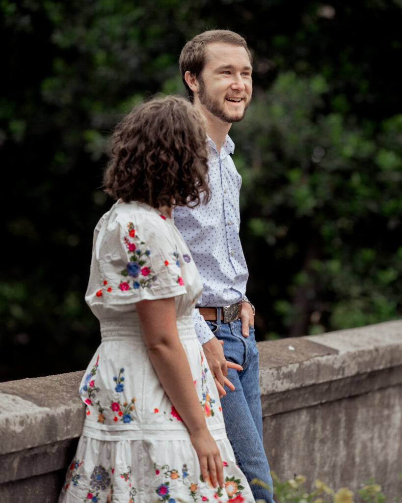 A catholic bride and groom share a laugh during their catholic engagement session at centennial park in nashville, tn