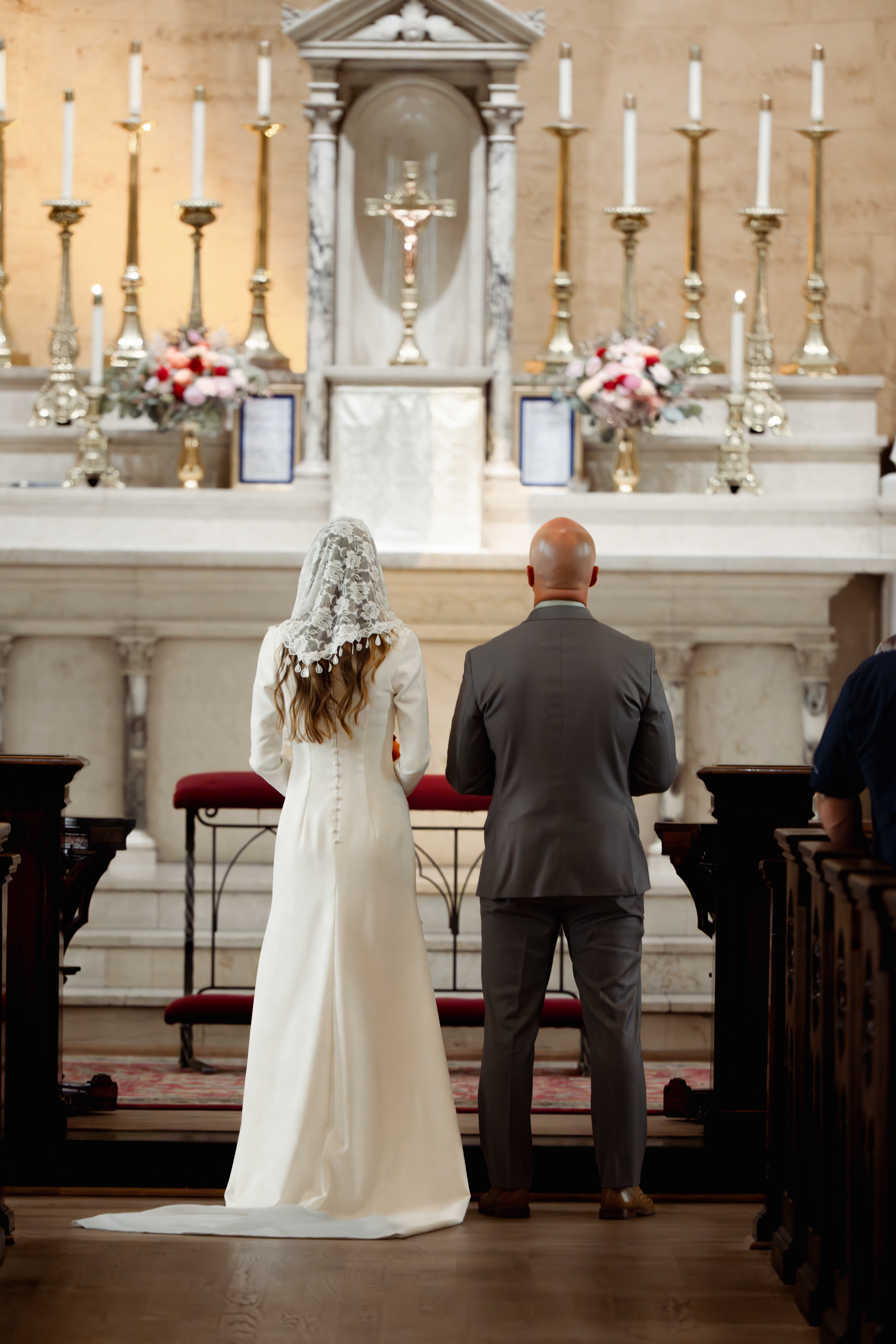 A catholic bride and groom stand at the altar during their catholic wedding Mass at St. Mary's of the Seven sorrows in downtown Nashville, tn