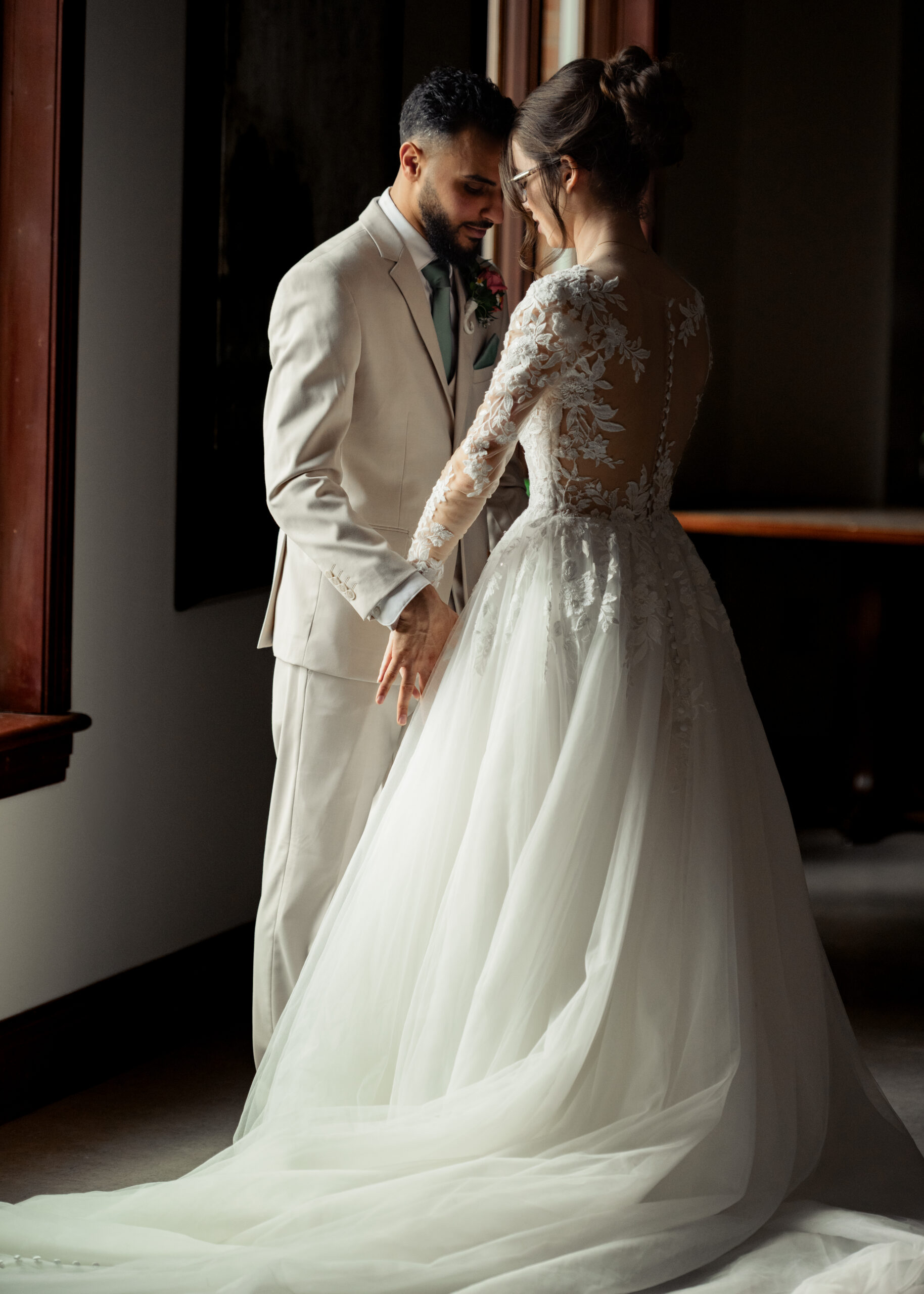 A bride and groom share an intimate moment during their first look at Holy Family catholic church in Nashville ahead of their catholic wedding Mass.