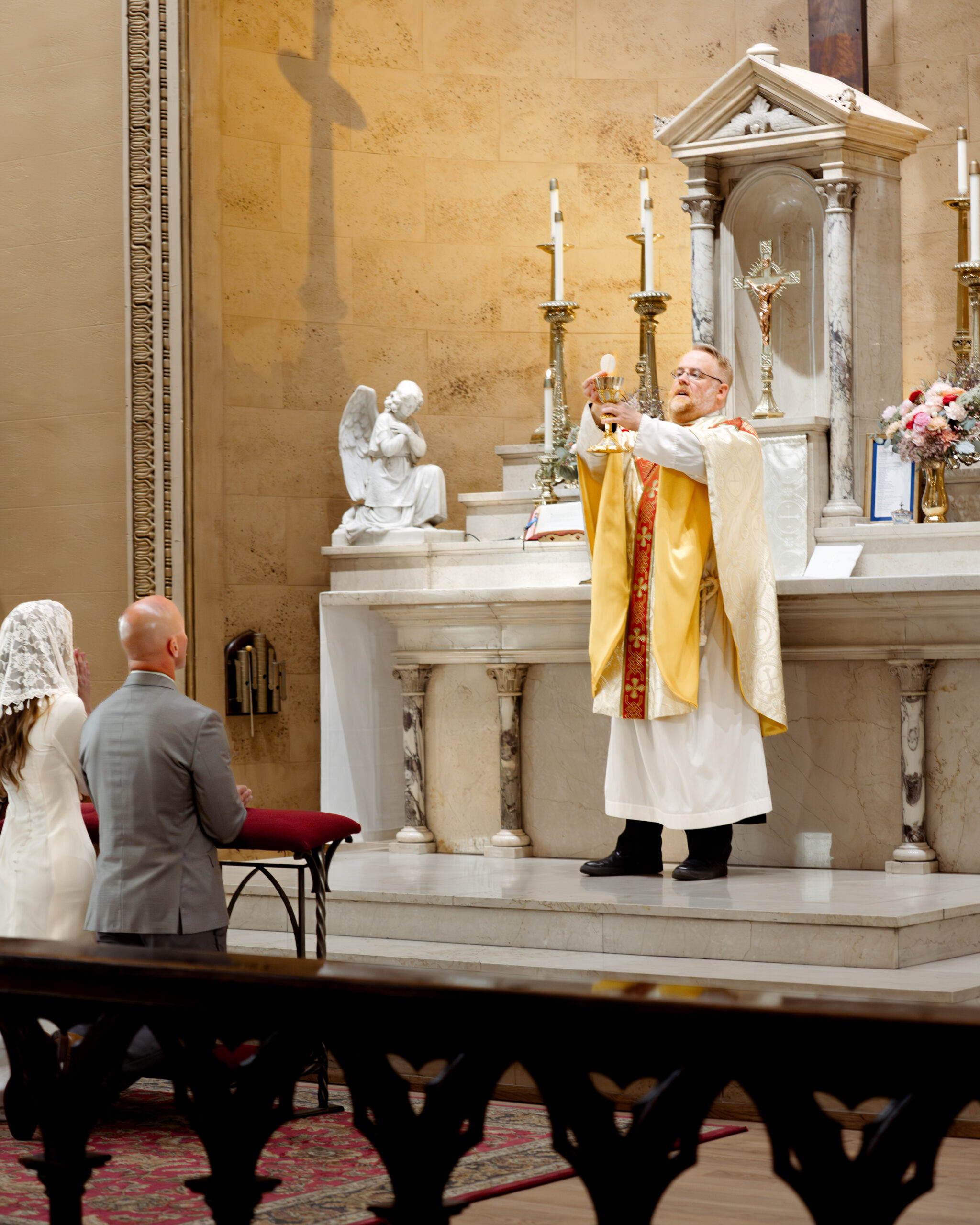 A catholic bride and groom prepare to receive communion during their catholic wedding Mass at St. Mary's of the Seven sorrows in downtown Nashville, tn