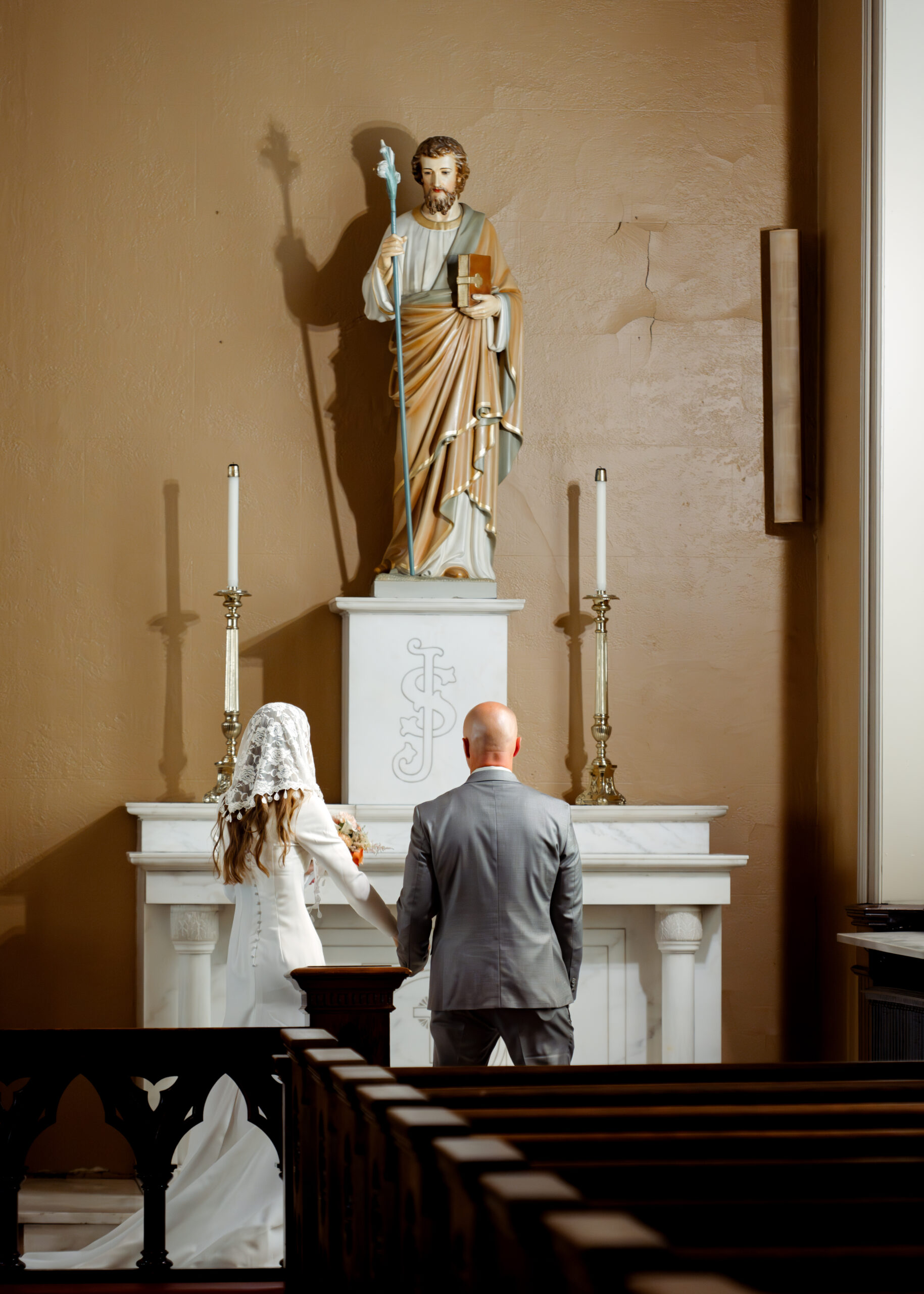 A catholic bride and groom prayerfully dedicate their marriage to st. joseph during their catholic wedding Mass at St. Mary's of the Seven sorrows in downtown Nashville, tn