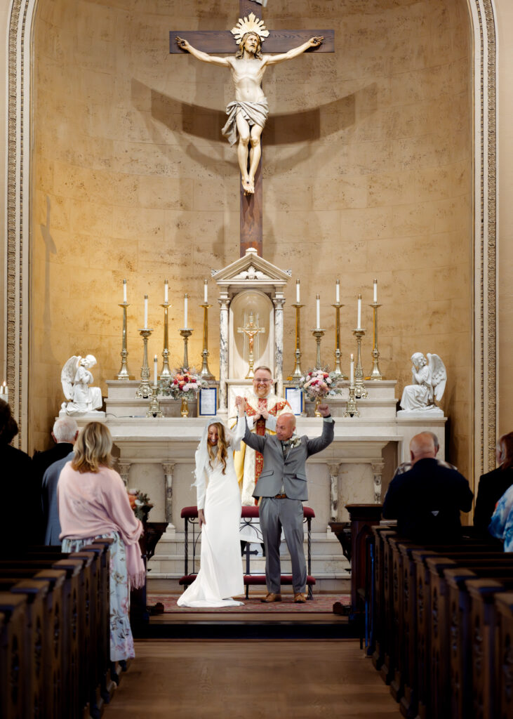 A catholic bride and groom celebrate at the end of their catholic wedding Mass at St. Mary's of the Seven sorrows in downtown Nashville, tn