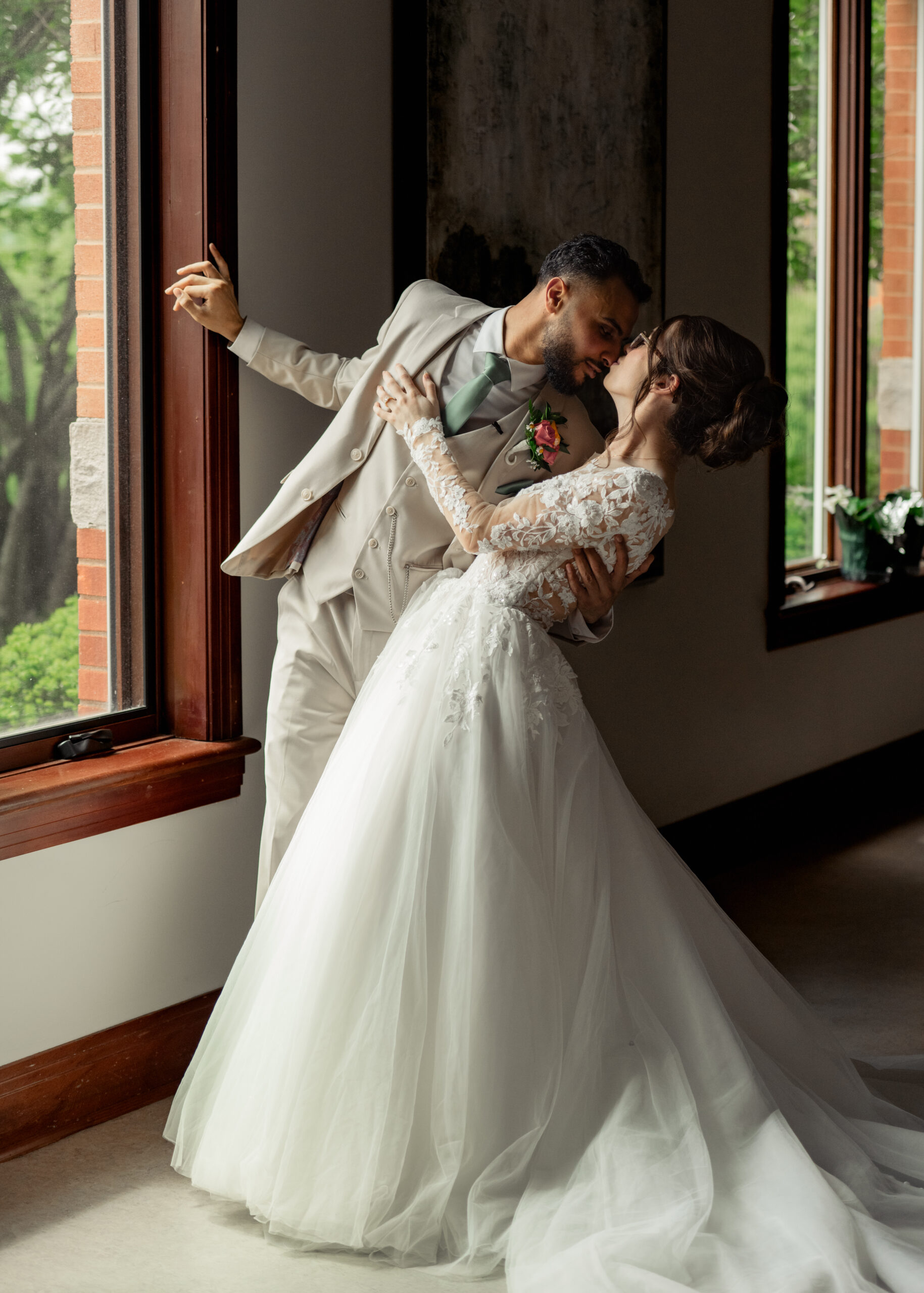 A bride and groom pose for a dip portrait during their first look at Holy Family catholic church in Nashville ahead of their catholic wedding Mass.