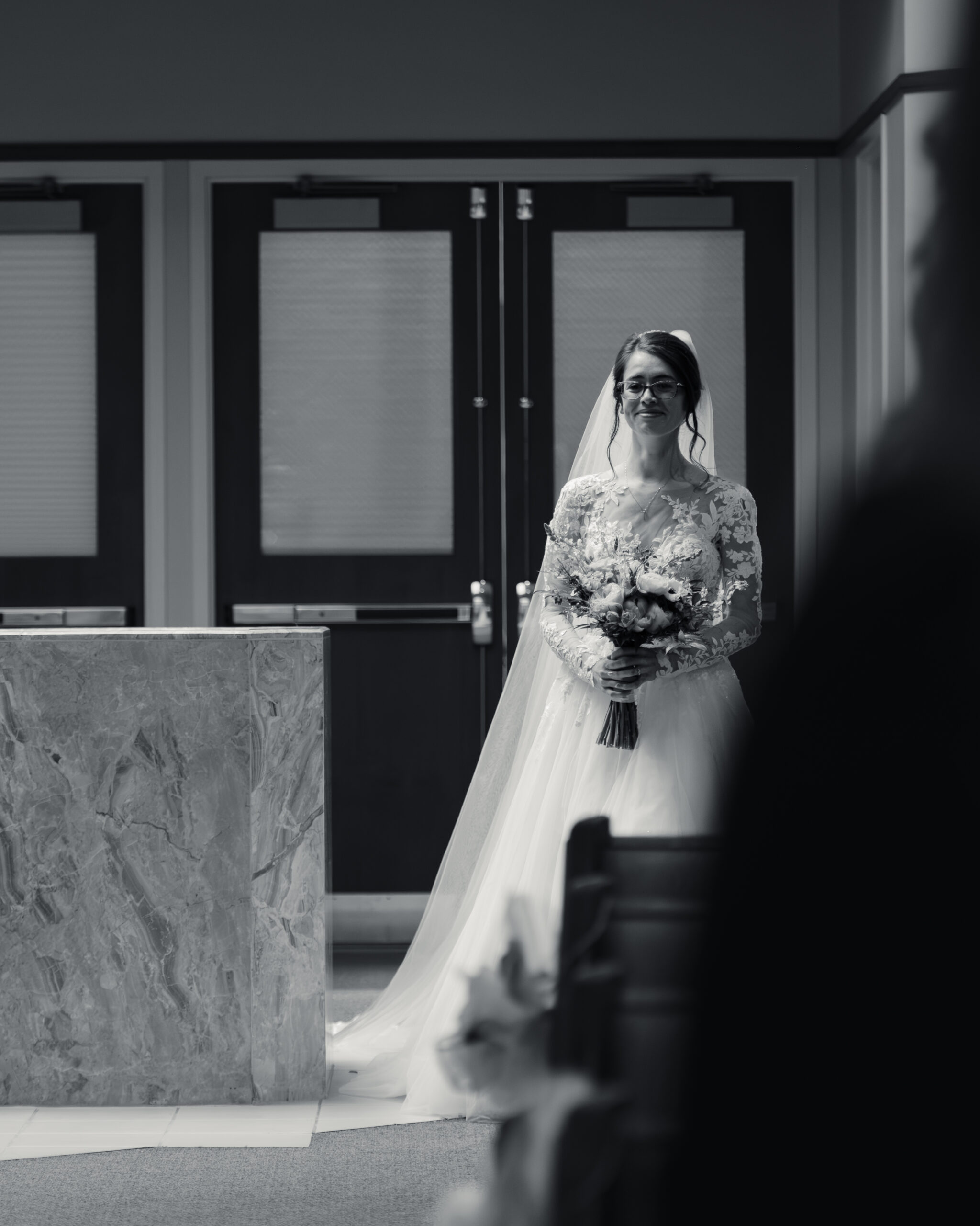 A catholic bride walks down the aisle during a catholic wedding Mass at Holy Family Catholic Church in Brentwood, TN.