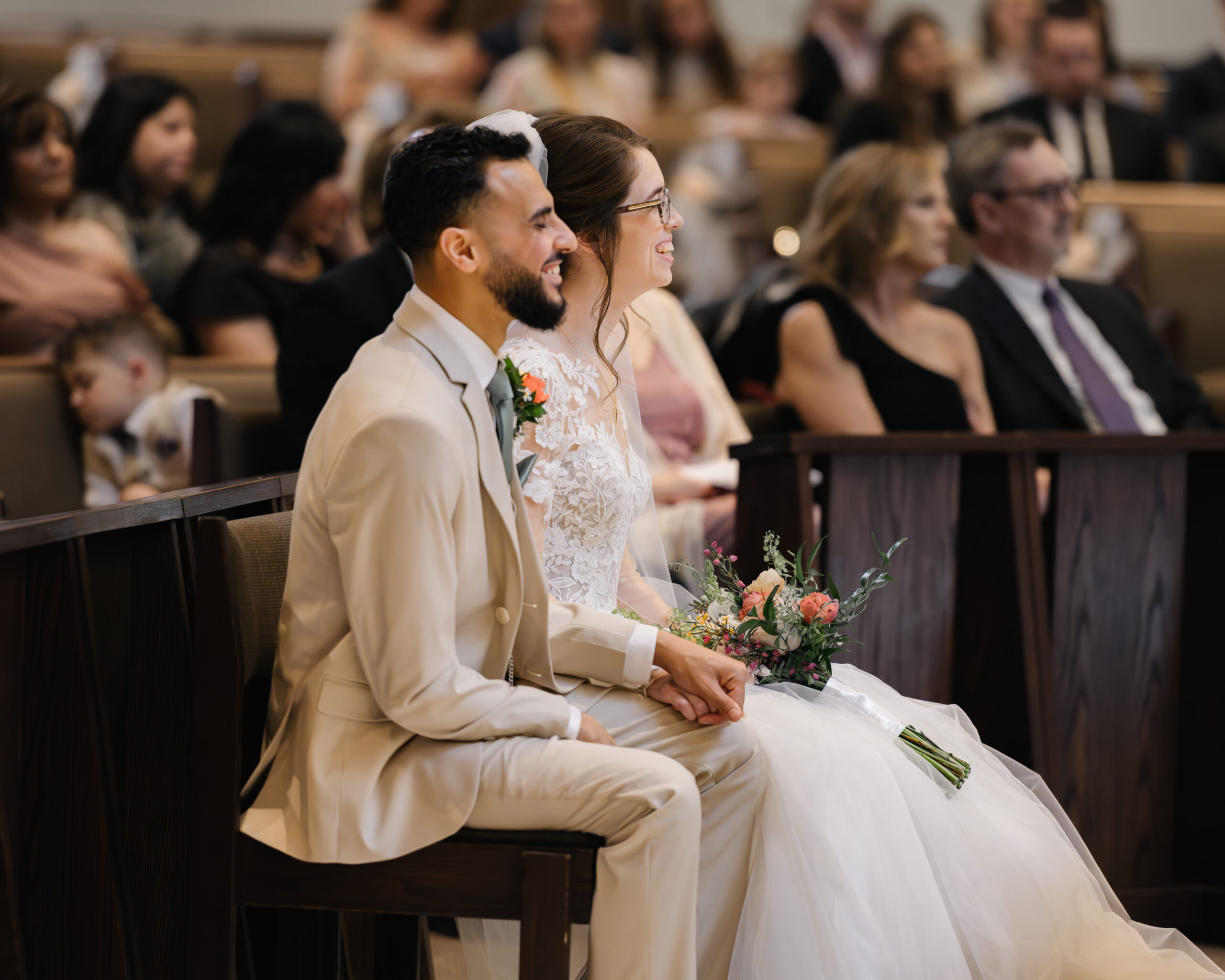 A bride and groom laugh during a catholic wedding Mass at Holy Family Catholic Church in Brentwood, TN.