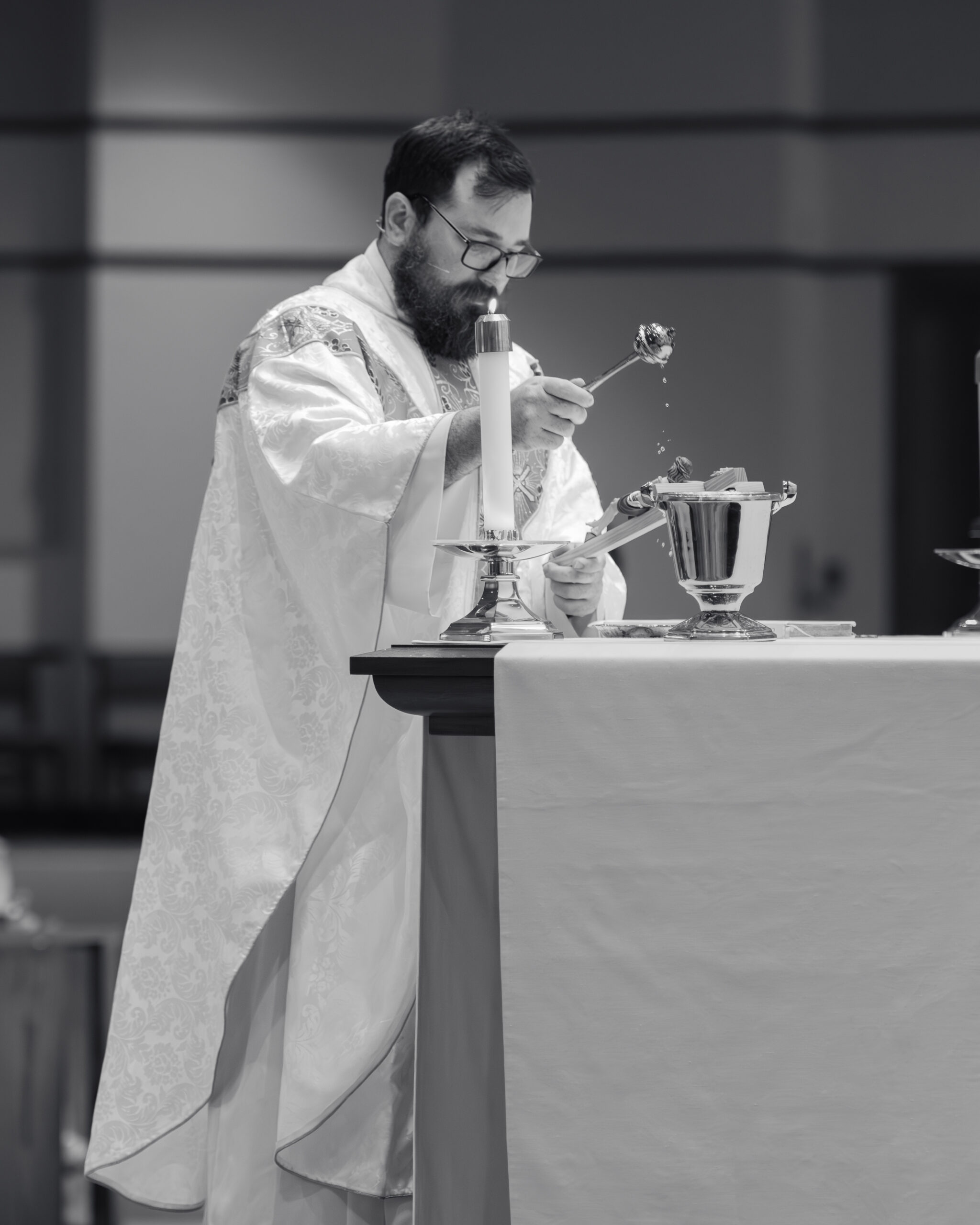 A catholic priest blesses a crucifix that the couple will hold as they exchange vows during a catholic wedding Mass at Holy Family Catholic Church in Brentwood, TN.