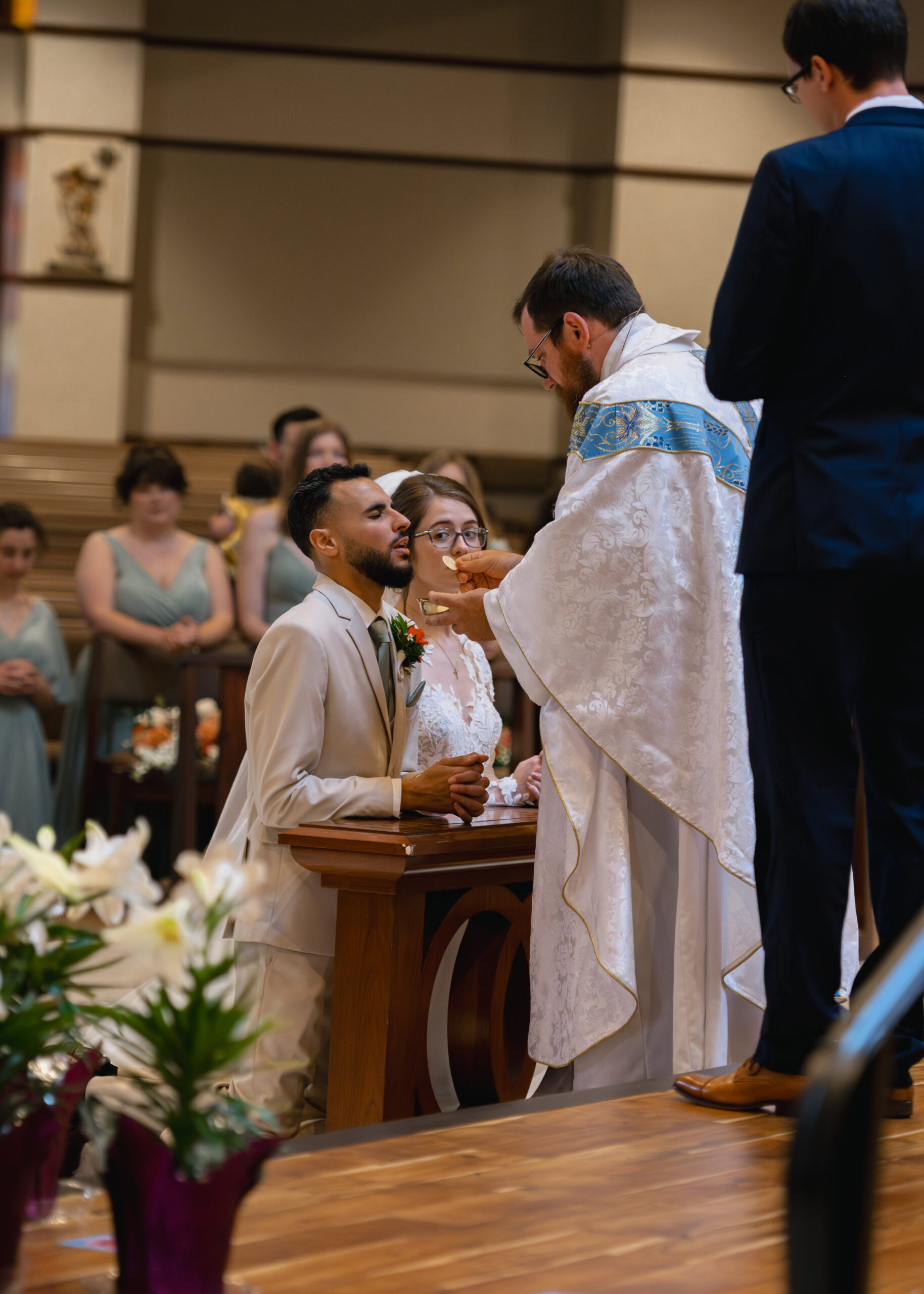 A bride and groom receive holy communion during a catholic wedding Mass at Holy Family Catholic Church in Brentwood, TN.