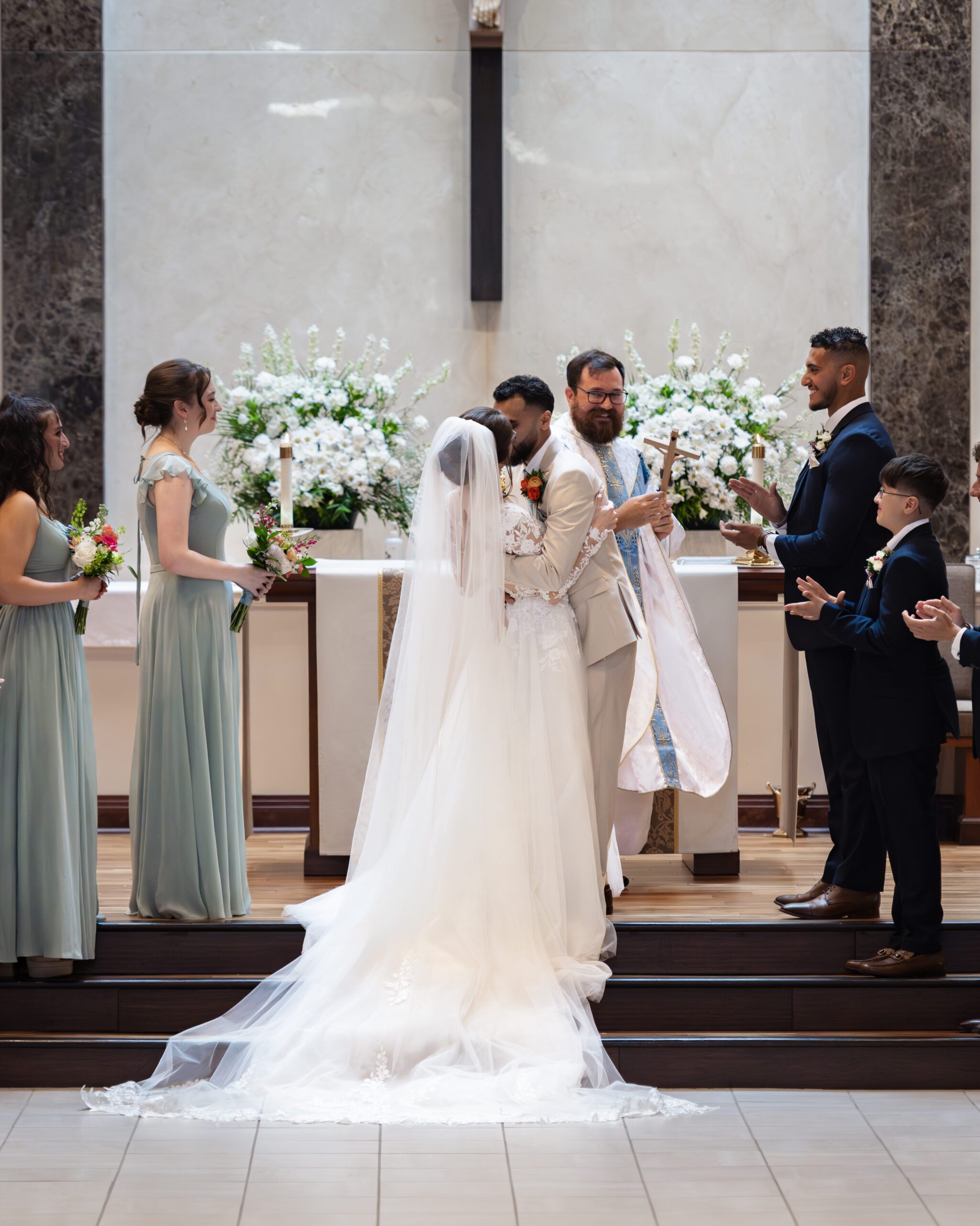 A catholic bride and groom share their first kiss at the altar during a catholic wedding Mass at Holy Family Catholic Church in Brentwood, TN.
