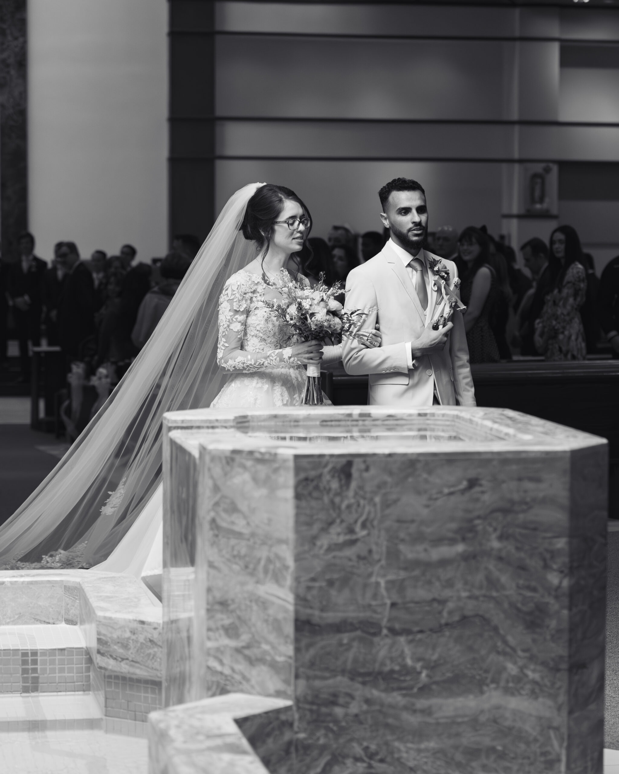 A catholic bride and groom walk back up the altar praying after their nashville catholic wedding mass at holy family catholic church in brentwood