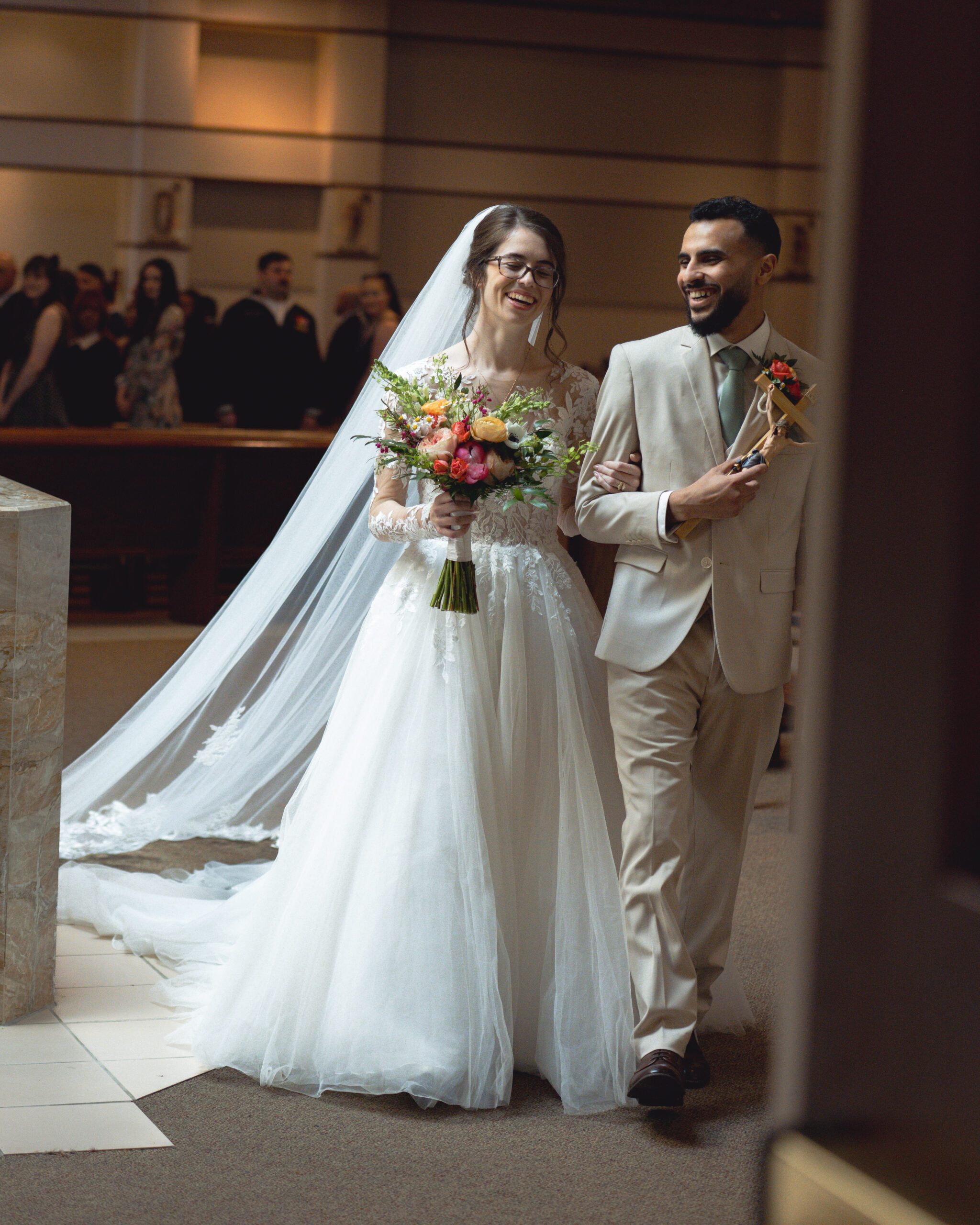A catholic bride and groom walk back up the altar laughing after their nashville catholic wedding mass at holy family catholic church in brentwood