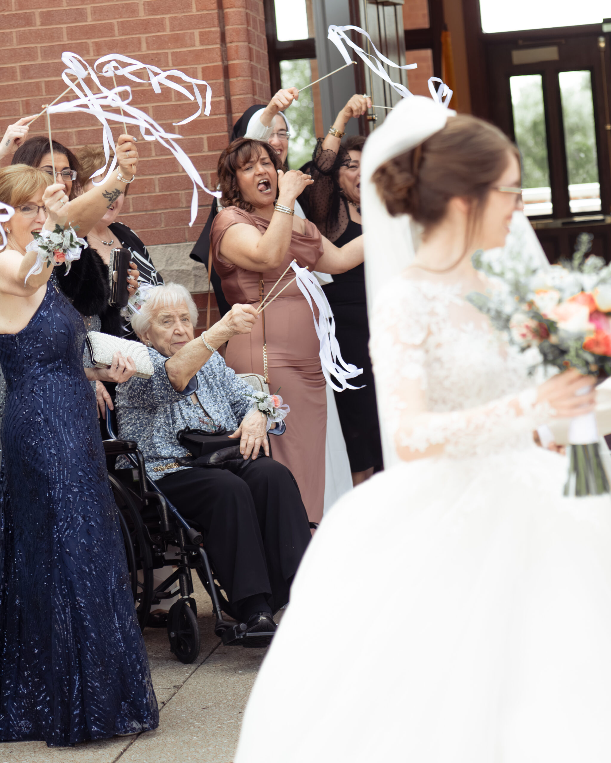 the groom's aunt cheers during a traditional church wedding exit outside of holy family catholic church in brentwood tn