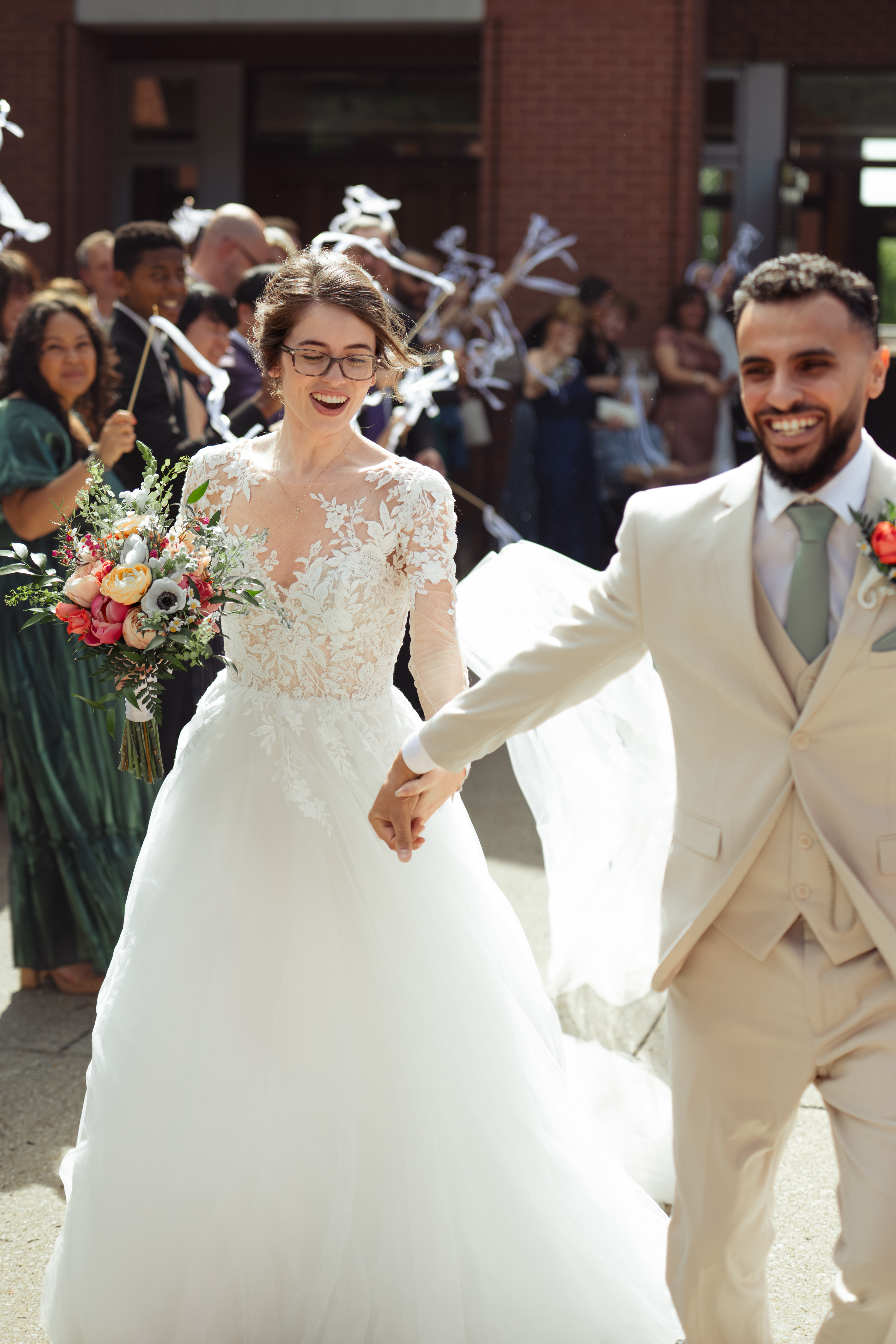 a catholic bride and groom joyfully run away during their traditional church exit outside of holy family catholic church in brentwood, tennessee