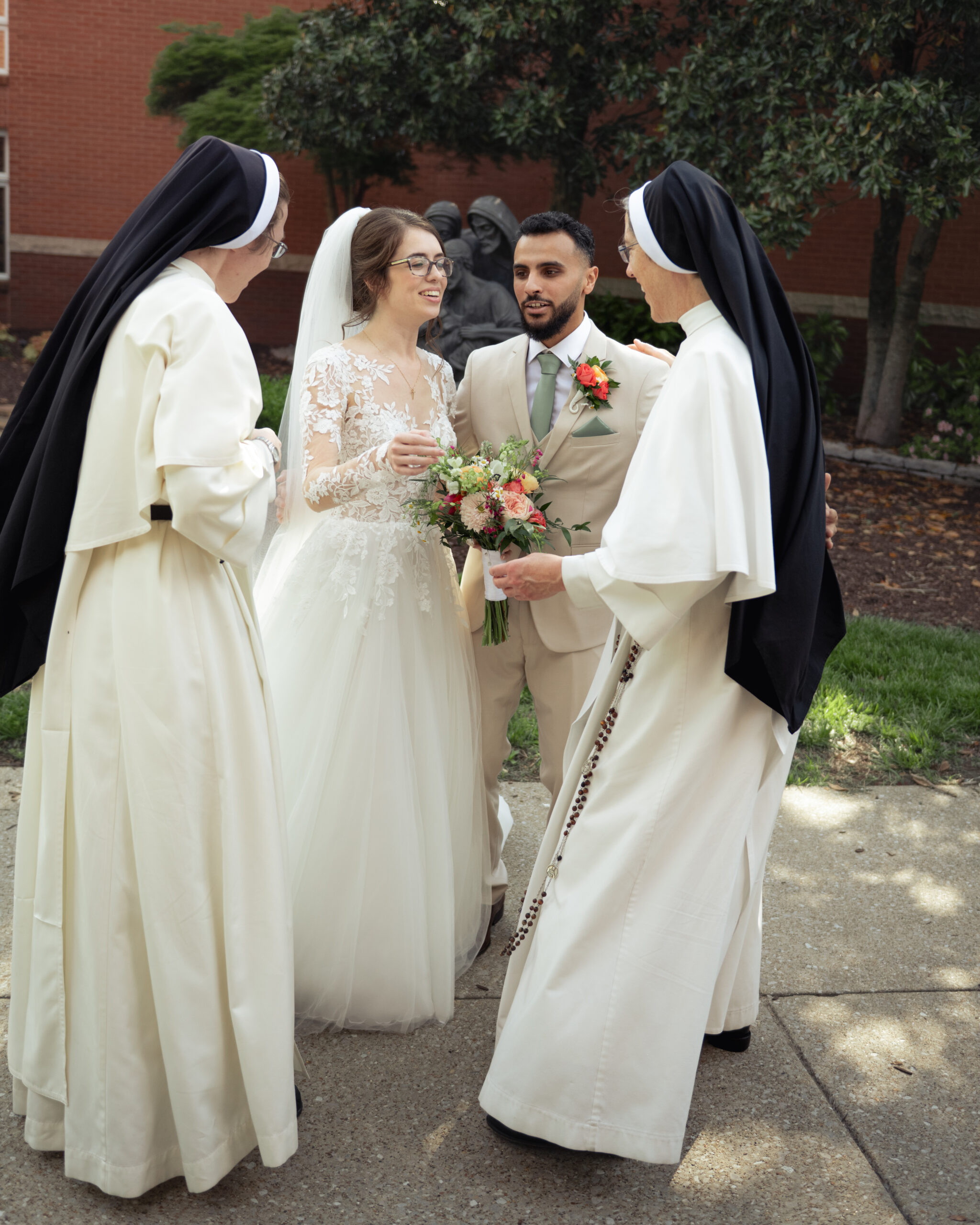 A catholic bride and groom talk to two Domincan sisters of st. cecilia after their catholic wedding mass at holy family catholic church in brentwood, tn.