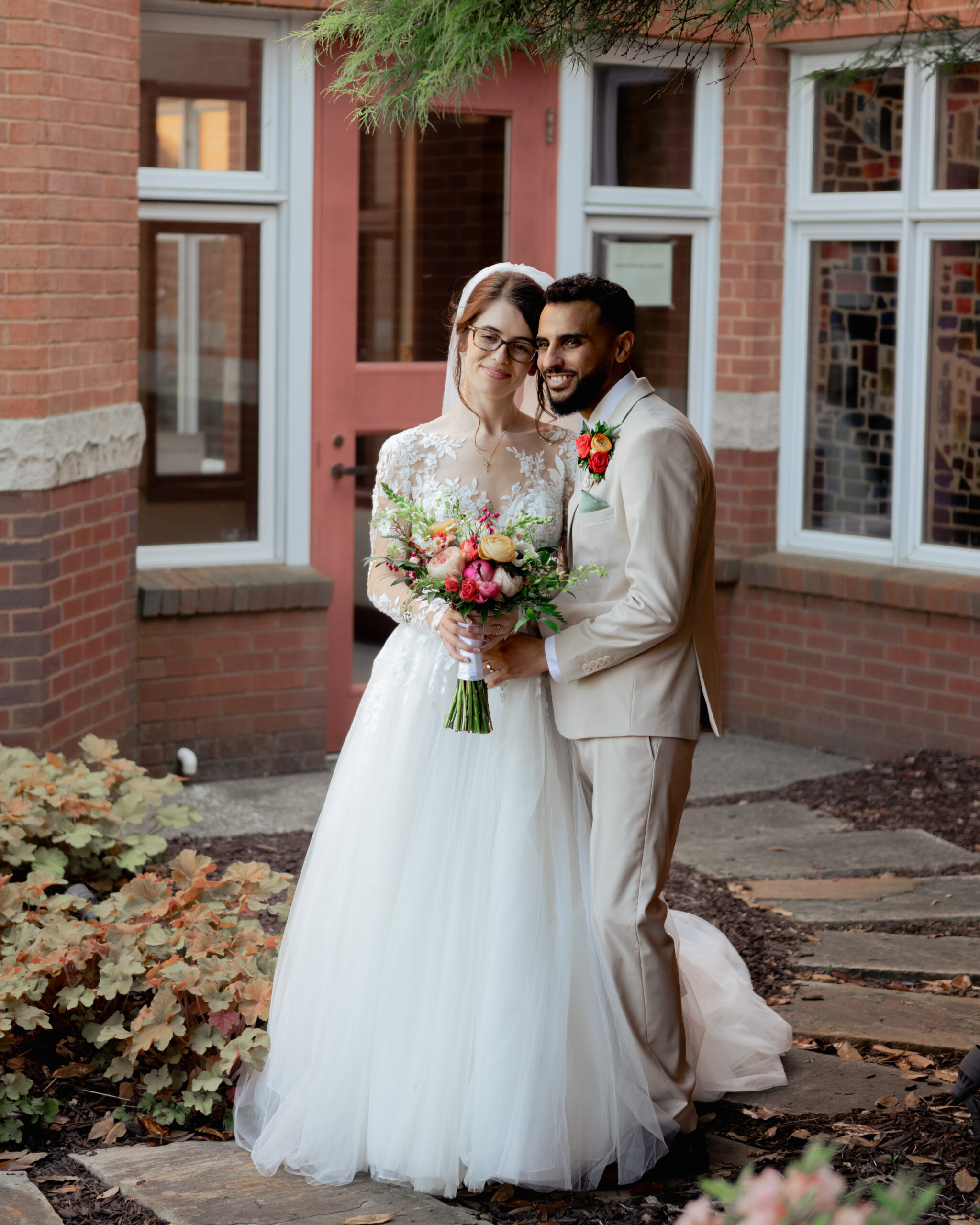 A catholic bride and groom share an intimate moment while smiling at a videographer after their catholic wedding mass in nashville, tn
