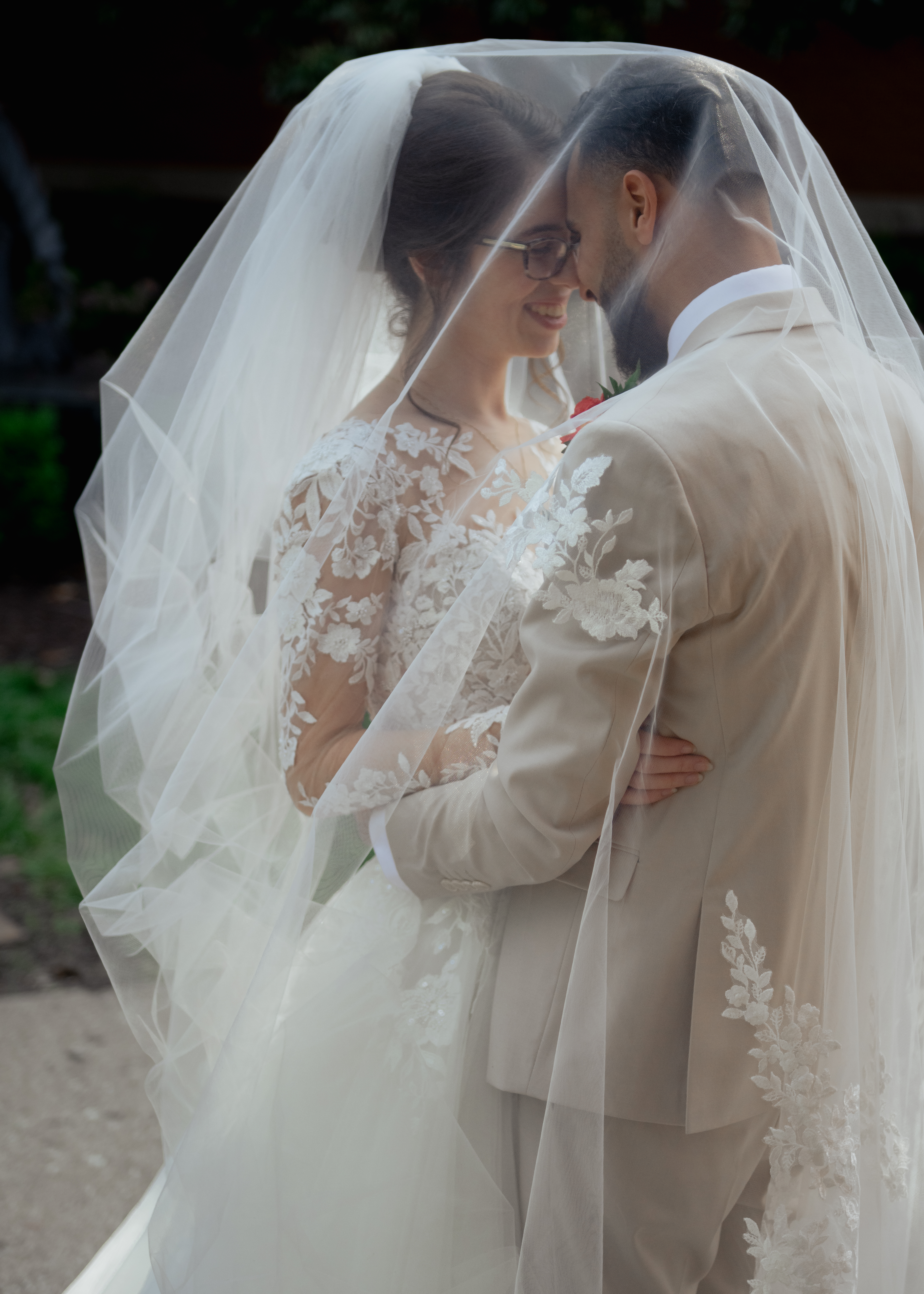 A catholic bride and groom share an intimate moment under the bride's veil after their catholic wedding mass in nashville, tn