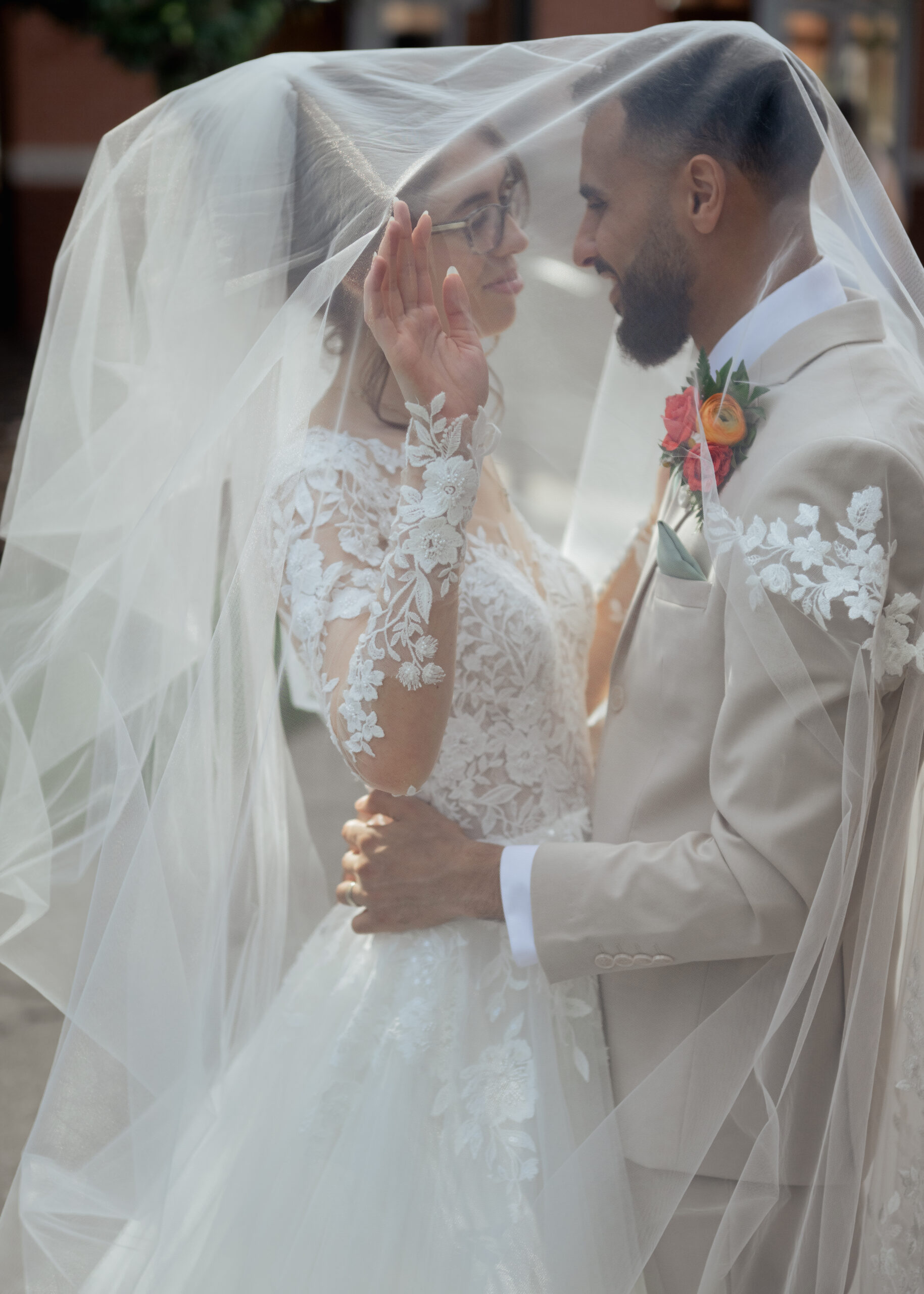 A catholic bride and groom share an intimate moment under the bride's veil after their catholic wedding mass in nashville, tn