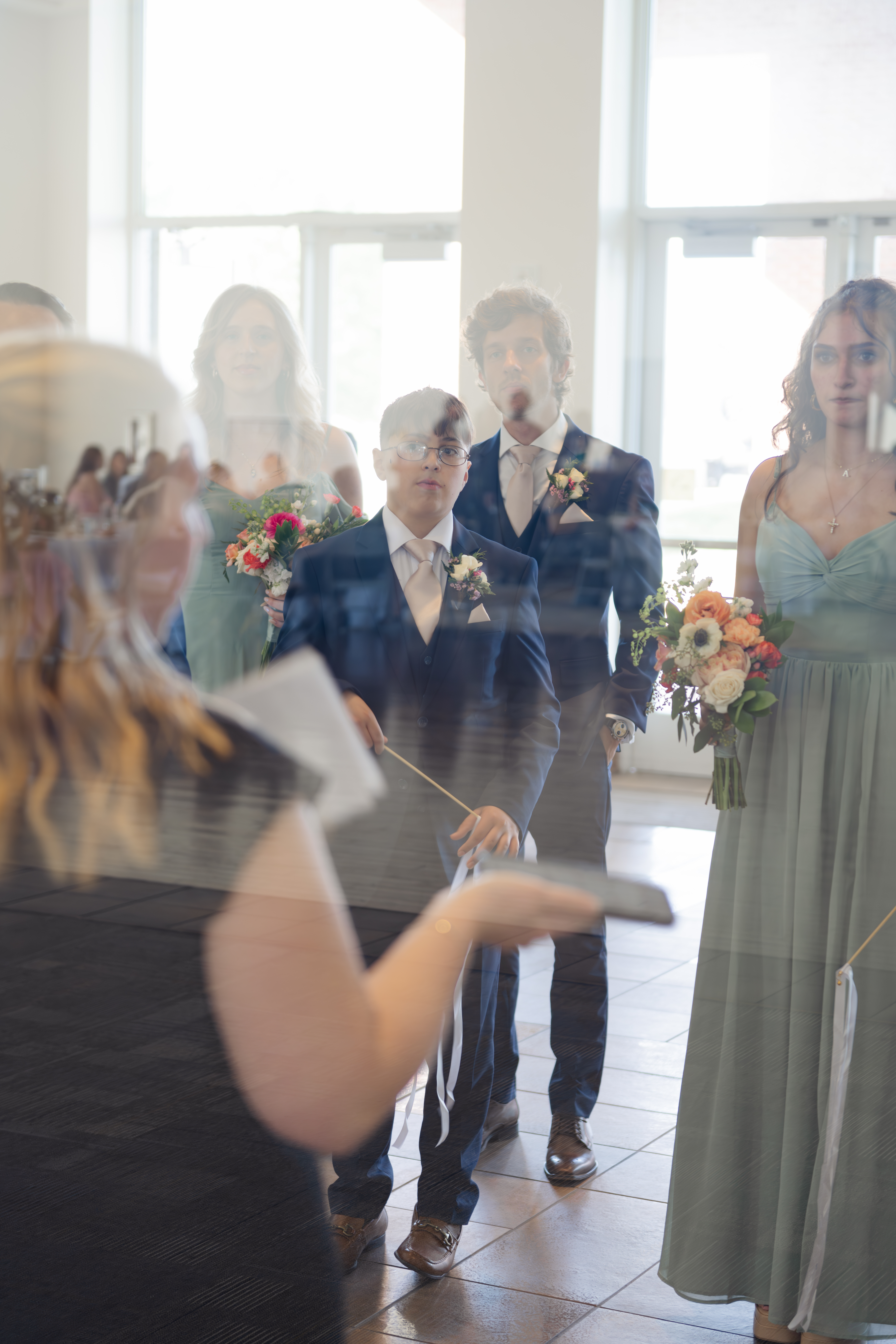 A bridal party briefs with a wedding planner before their grand entrance at a catholic wedding reception at holy family catholic church in brentwood, tn