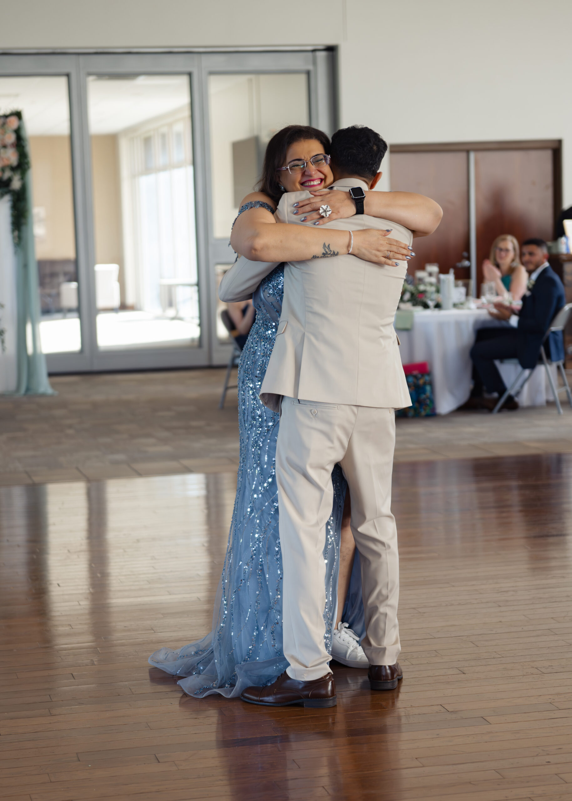 The mother of the groom gives her catholic groom son a hug after their dance at a catholic wedding reception at holy family catholic church in brentwood, tn