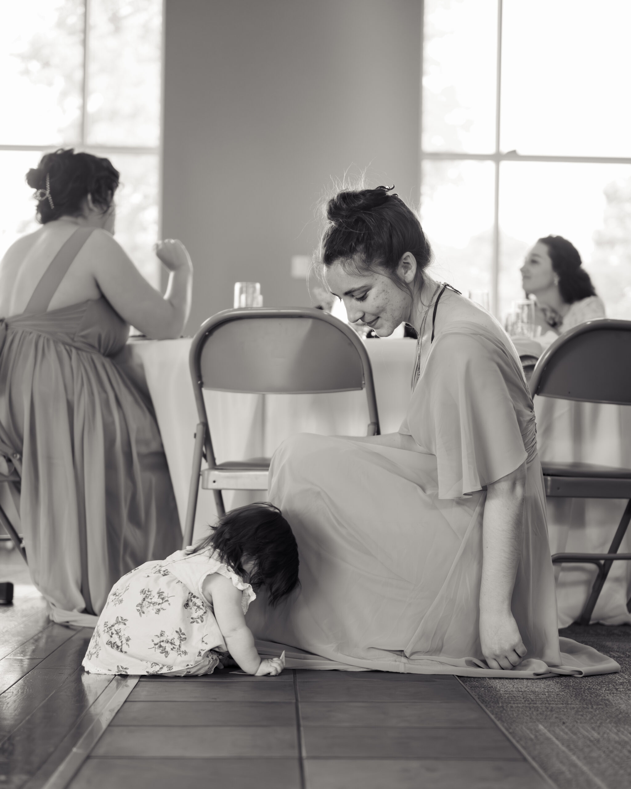 bridesmaids and a baby enjoy cocktail hour at a catholic wedding reception at holy family catholic church in brentwood, tn