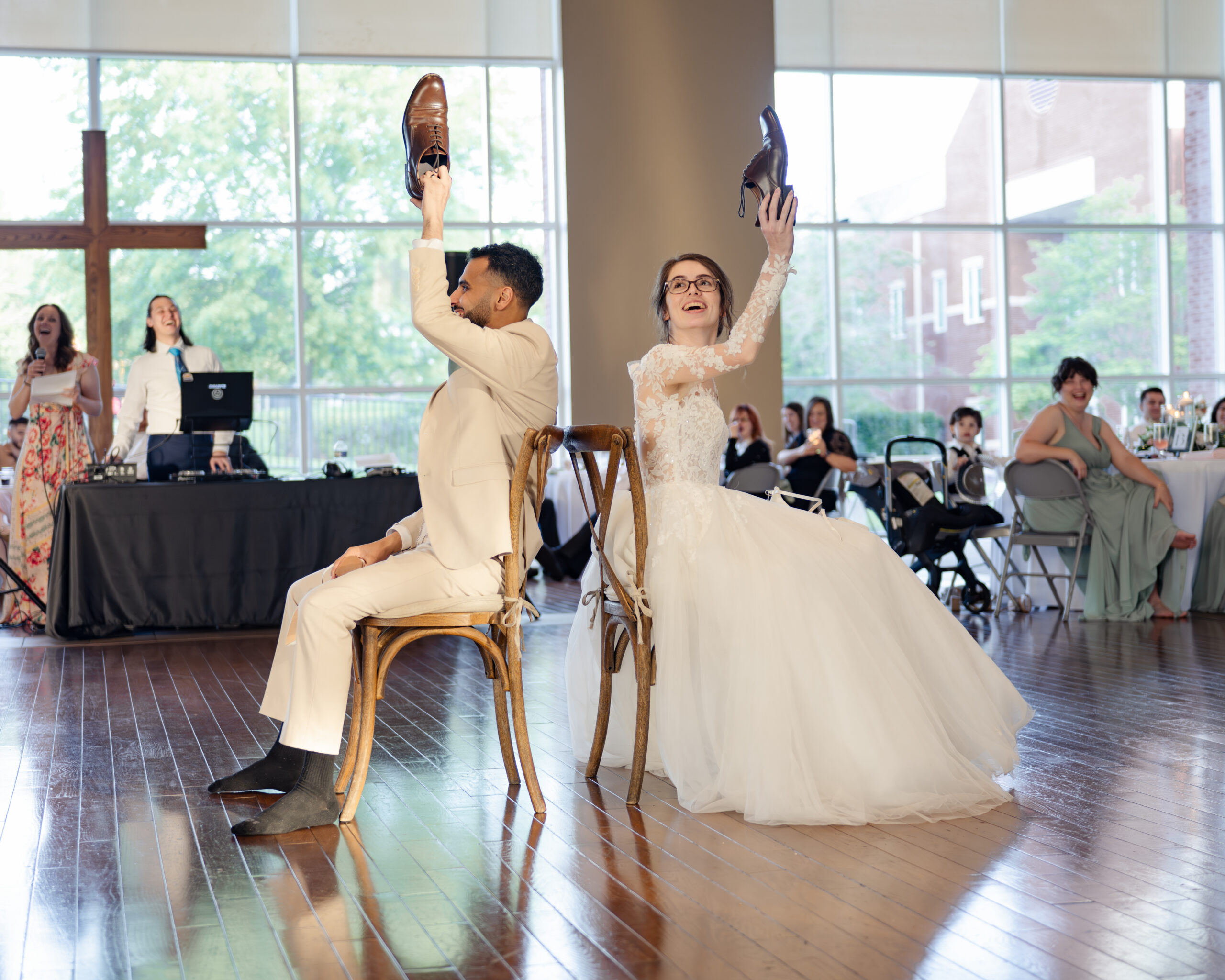A catholic bride and groom play the shoe game at a catholic wedding reception at holy family catholic church in brentwood, tn