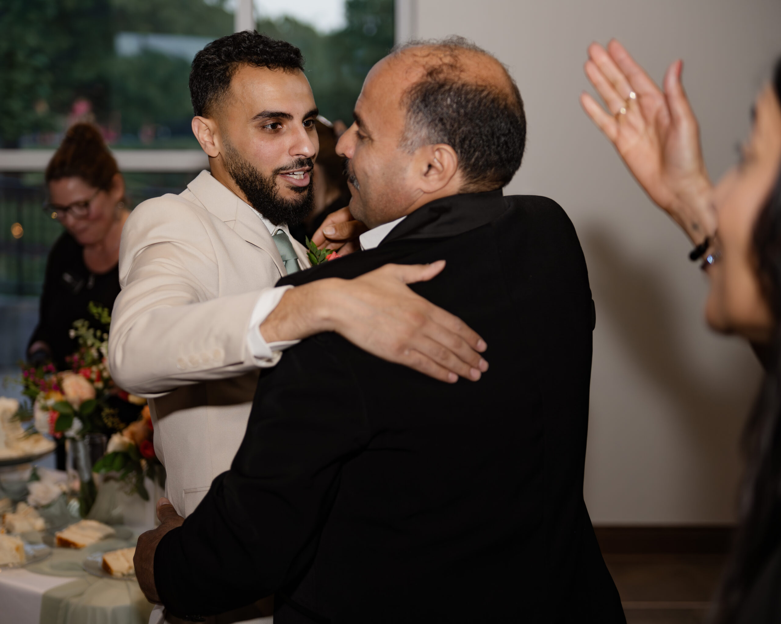 A catholic groom gives a family member a hug in this candid at A catholic bride and groom share an intimate moment cutting cake at a catholic wedding reception at holy family catholic church in brentwood, tn