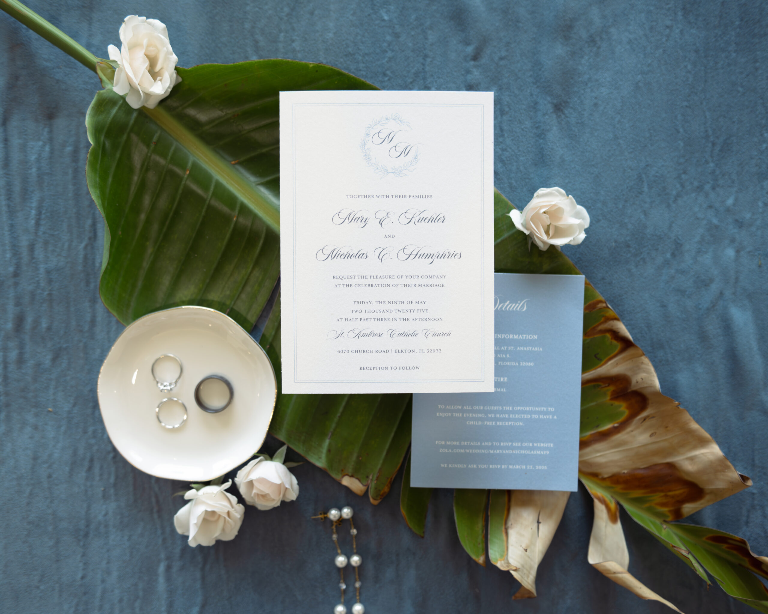 Elegant Catholic wedding invitation flat lay with rings, tropical leaves, and white roses – detail shot from a St. Augustine, Florida wedding