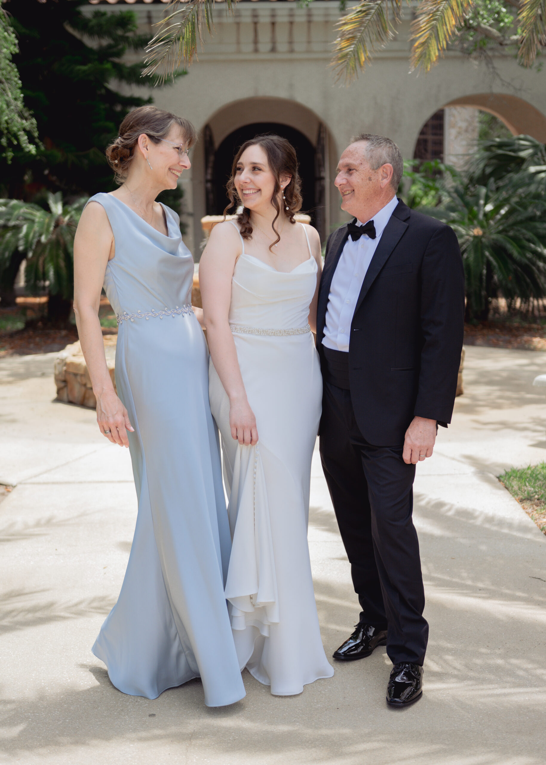 a catholic bride poses with her parents ahead of her catholic wedding ceremony in St. augustine florida.