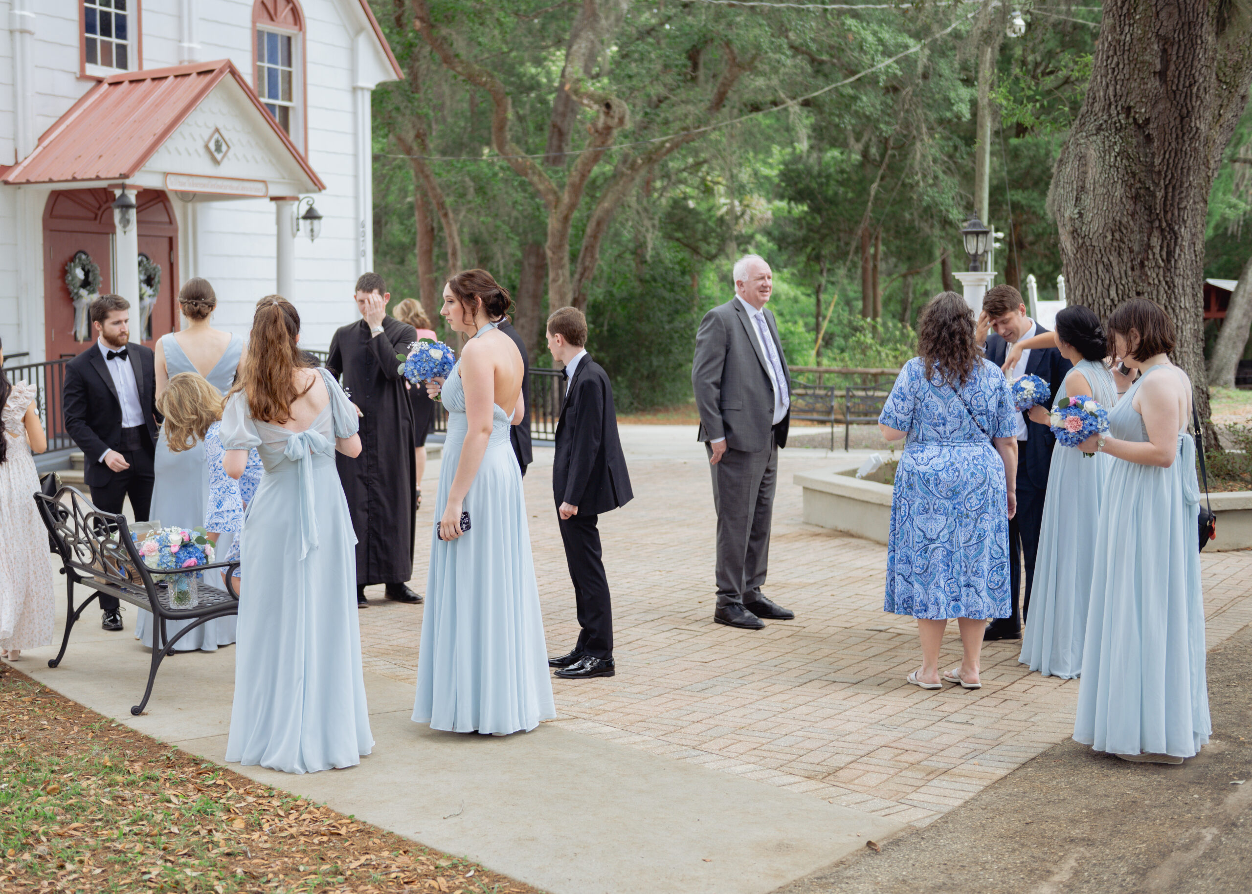 Wedding guests gather ahead of a catholic wedding Mass at st. ambrose catholic church in elkton, florida