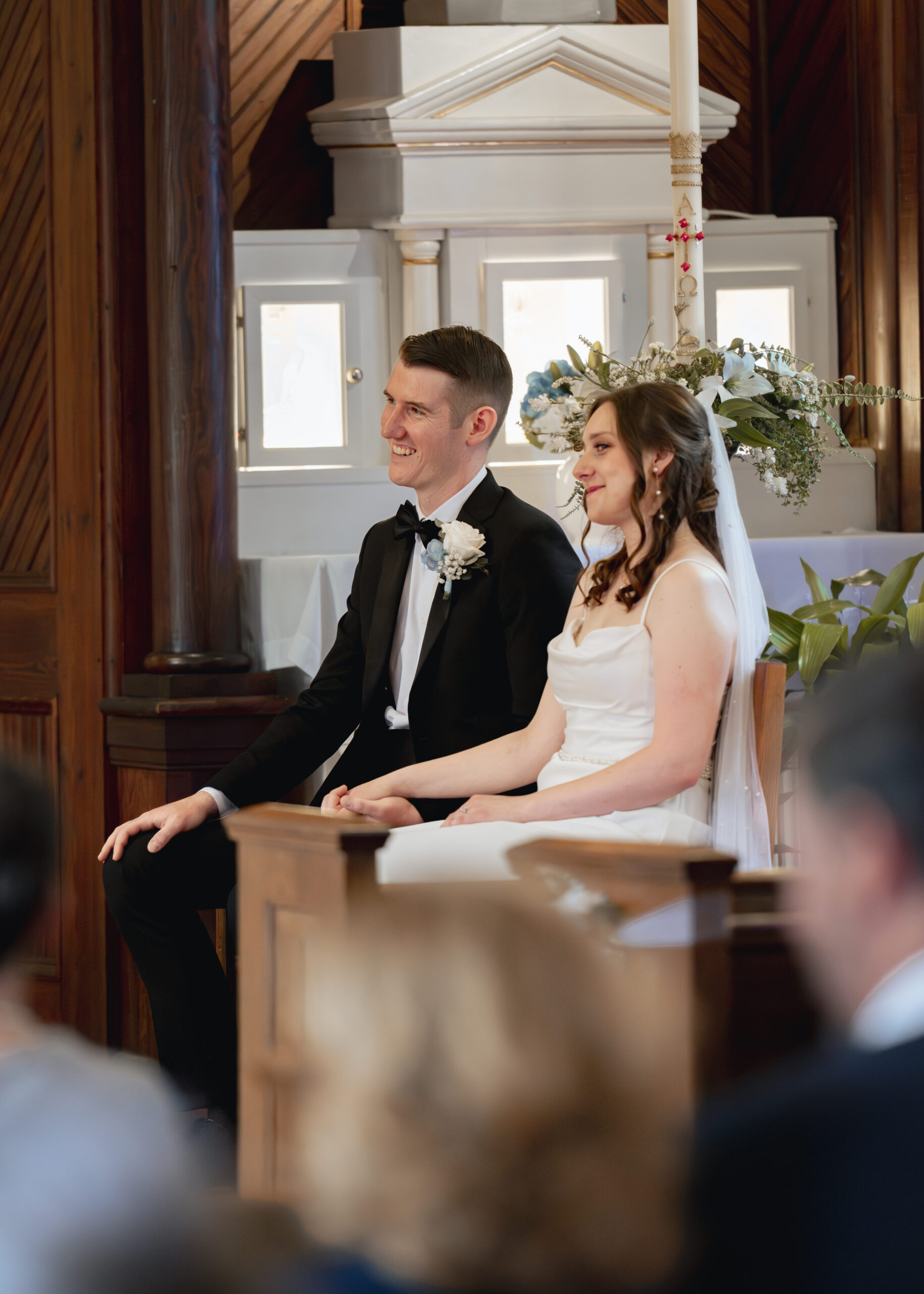 a catholic bride and groom laugh during their wedding mass at st. ambrose Catholic church in st. augustine florida
