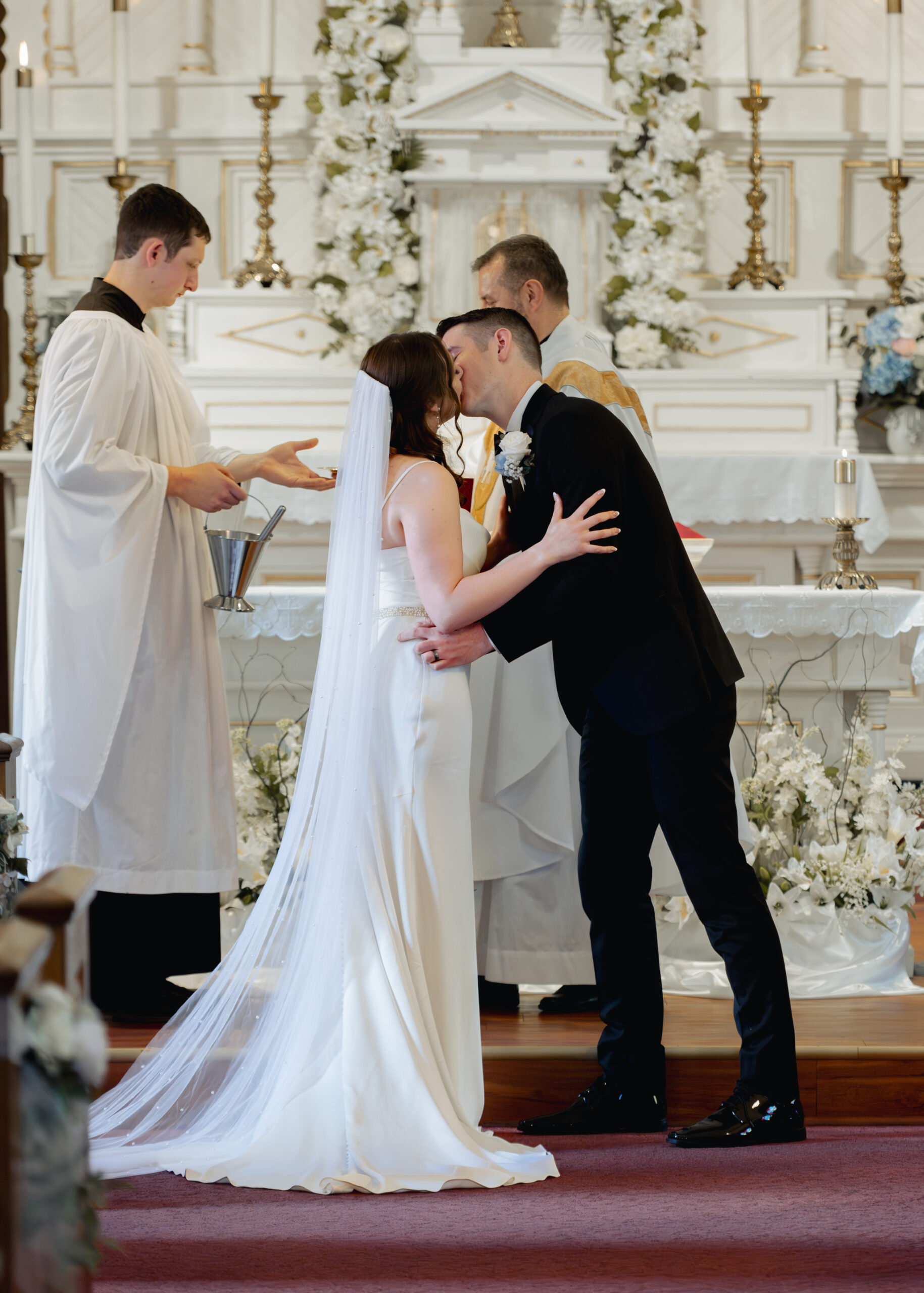 a catholic bride and groom share a kiss after their vows at st. ambrose Catholic church in st. augustine florida