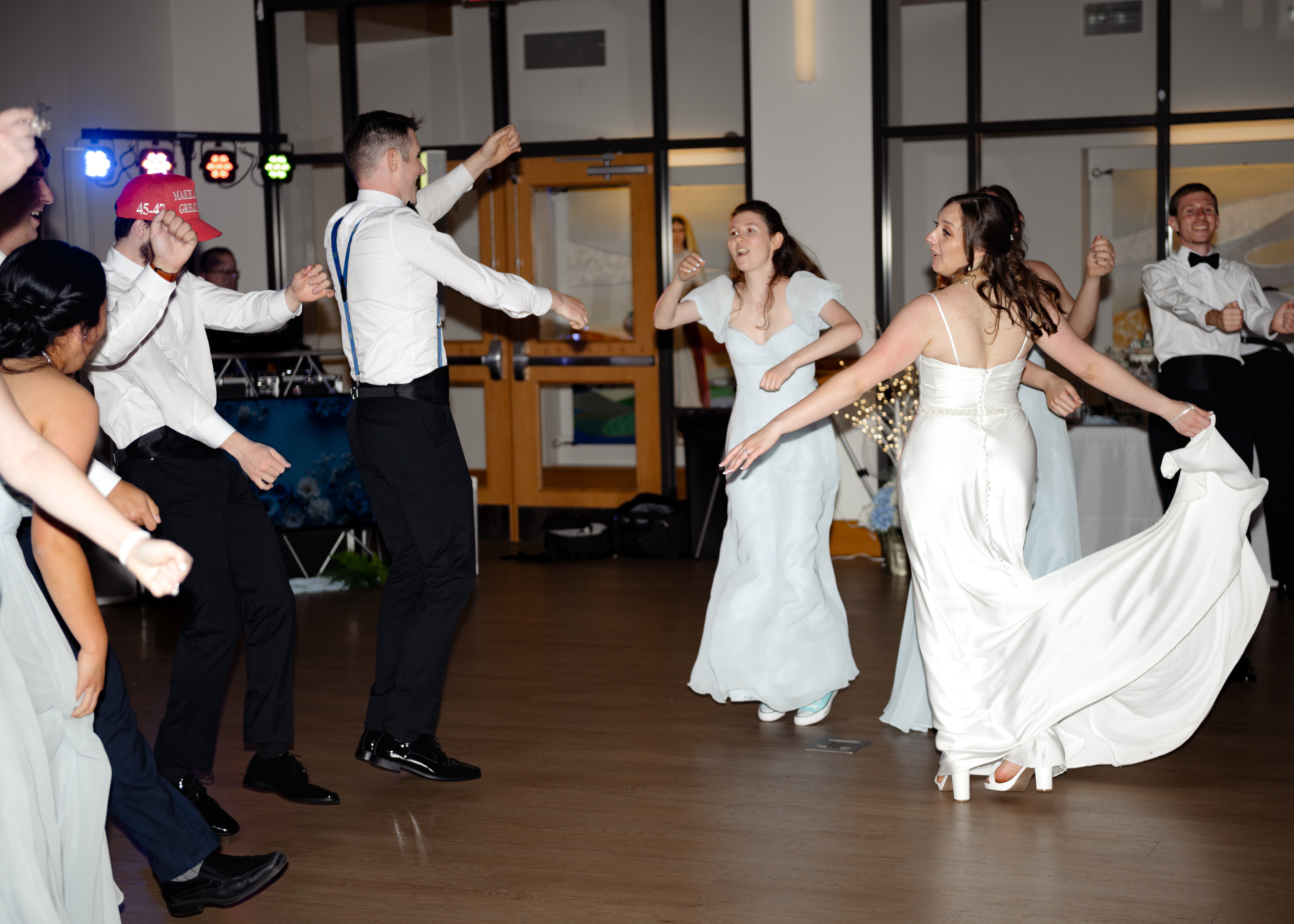 Bride, groom, and wedding guests enjoy lively dancing on the reception floor at St. Anastasia Catholic Church in St. Augustine, celebrating a traditional Catholic wedding.