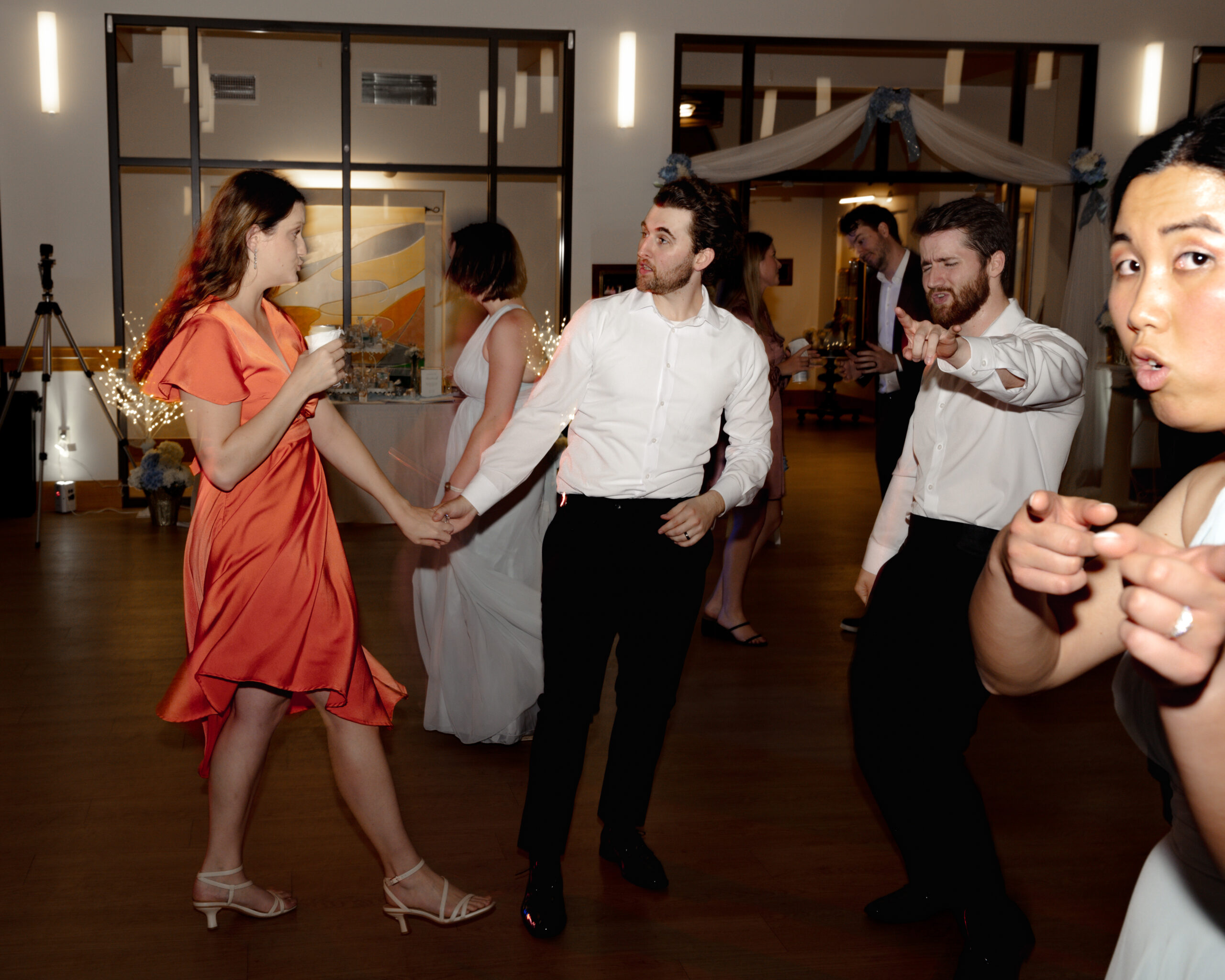 edding guests, dressed in formal evening wear, dance with the bride and groom during a Catholic wedding reception at St. Anastasia Catholic Church in St. Augustine, Florida.
