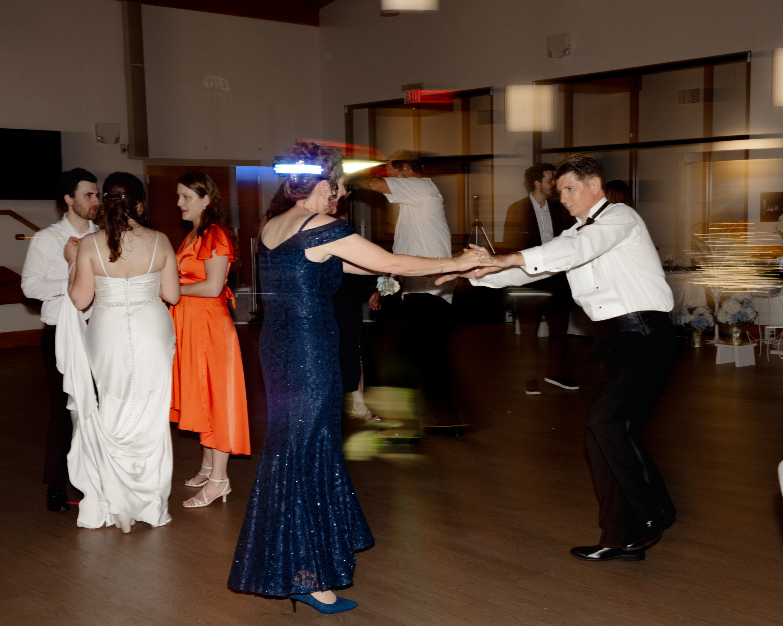 Couples dance under romantic lighting at a Catholic wedding reception at St. Anastasia Catholic Church in St. Augustine, Florida, with bride and groom enjoying the evening