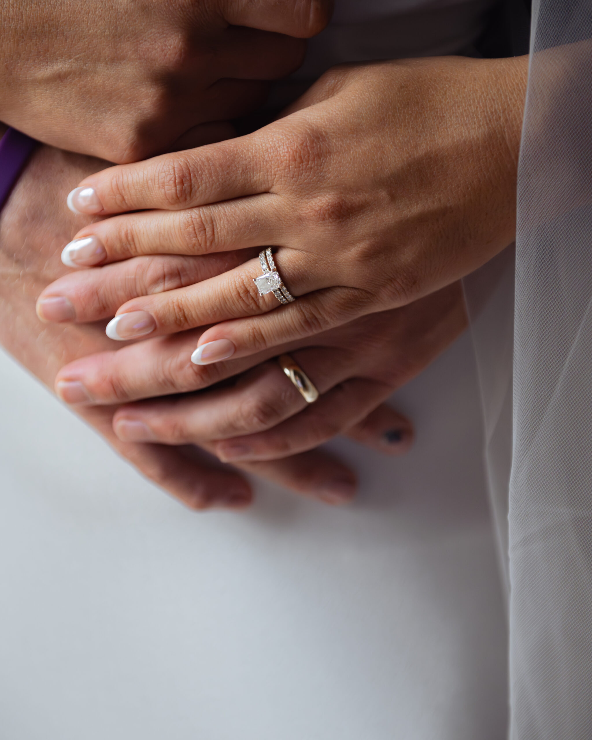 A details photograph of a catholic couple's hands showing off their new wedding bands at St. Ann's Catholic church in Nashville, TN