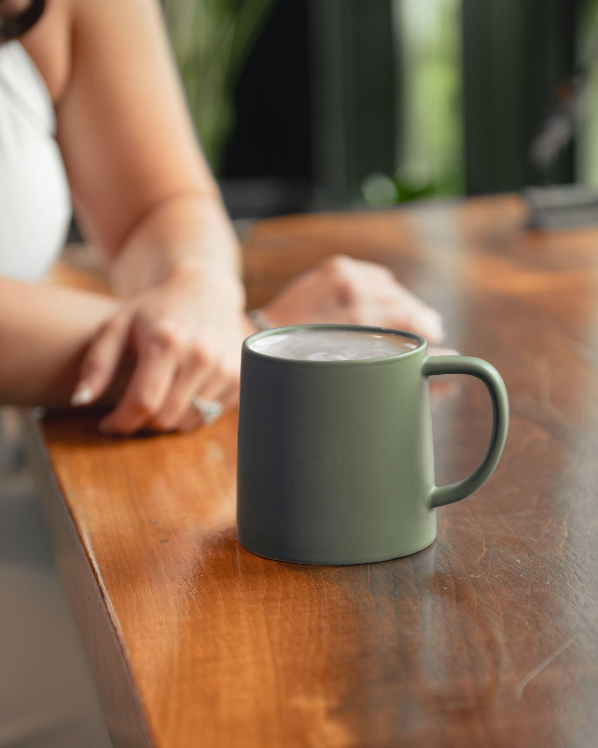 a warm image of a coffee mug and a hand wearing an engagement ring creates a warm and cozy tone for this summer engagement session in franklin, tn