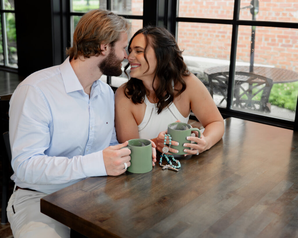A catholic couple shares an intimate moment during their engagement session at a franklin, tn coffee shop
