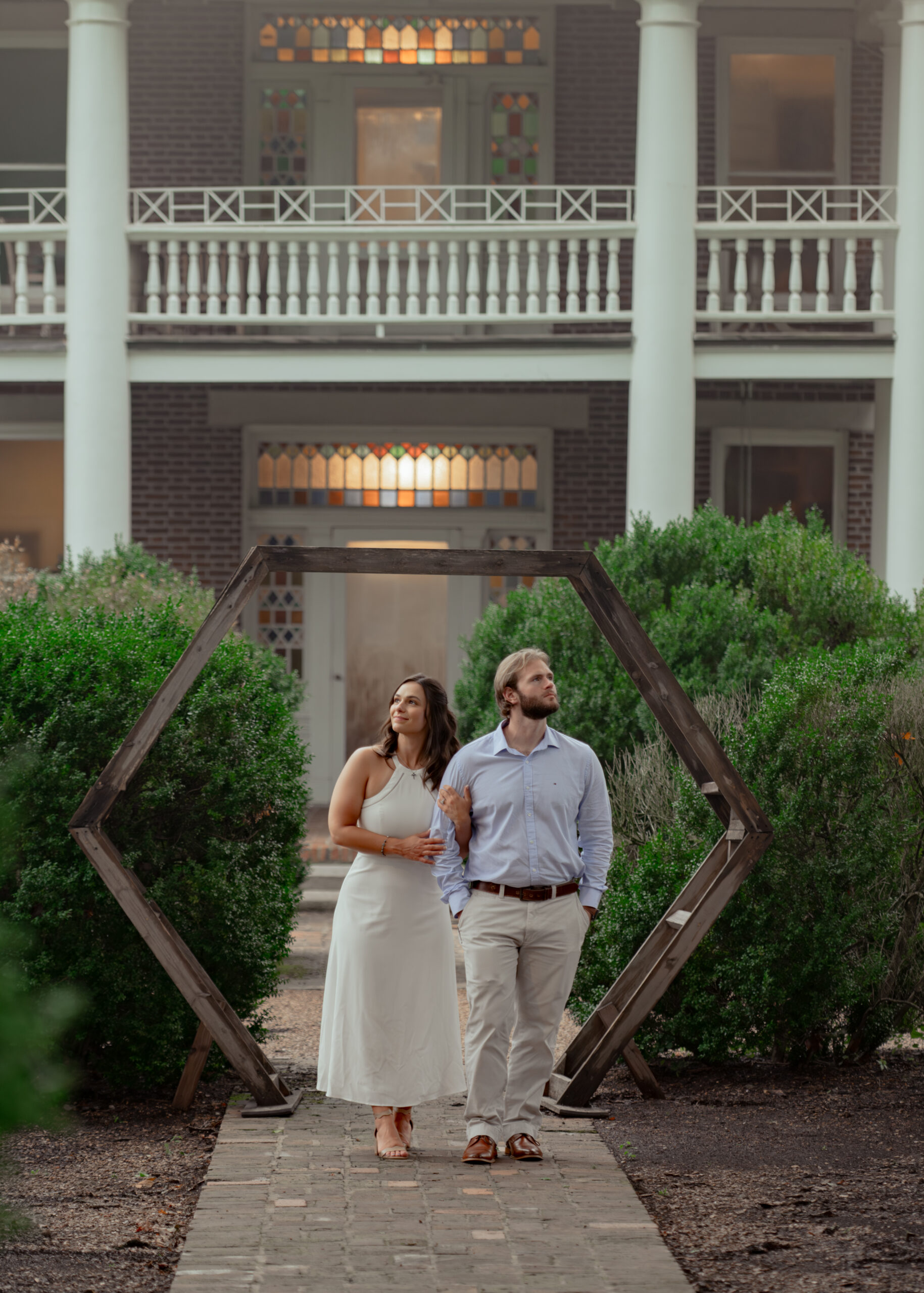 A catholic couple admires the gardens in this candid portrait during their summer tennessee engagement session