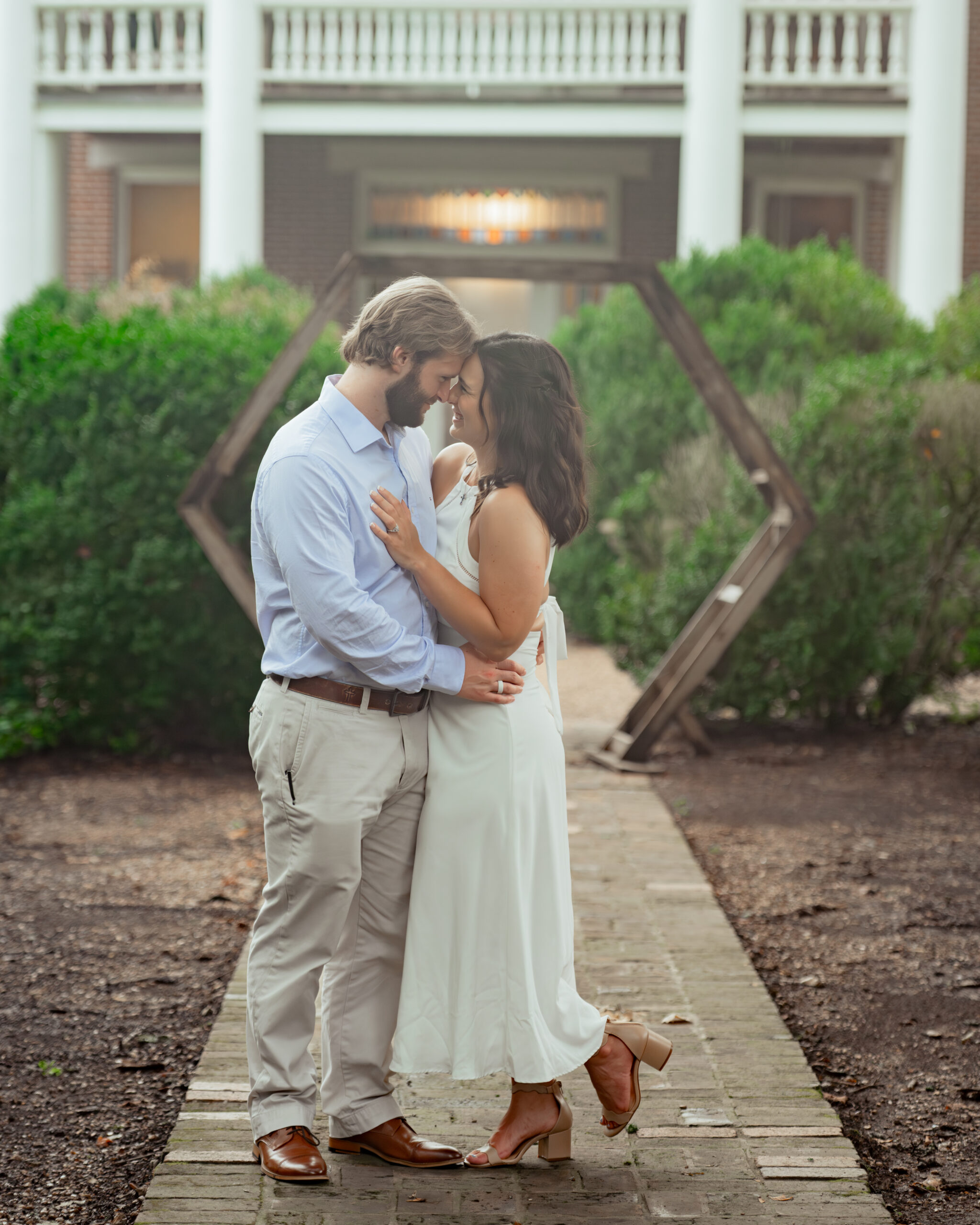 A catholic couple shares a romantic moment with cinematic hazy summer lighting in this thompson's station, tn engagement session