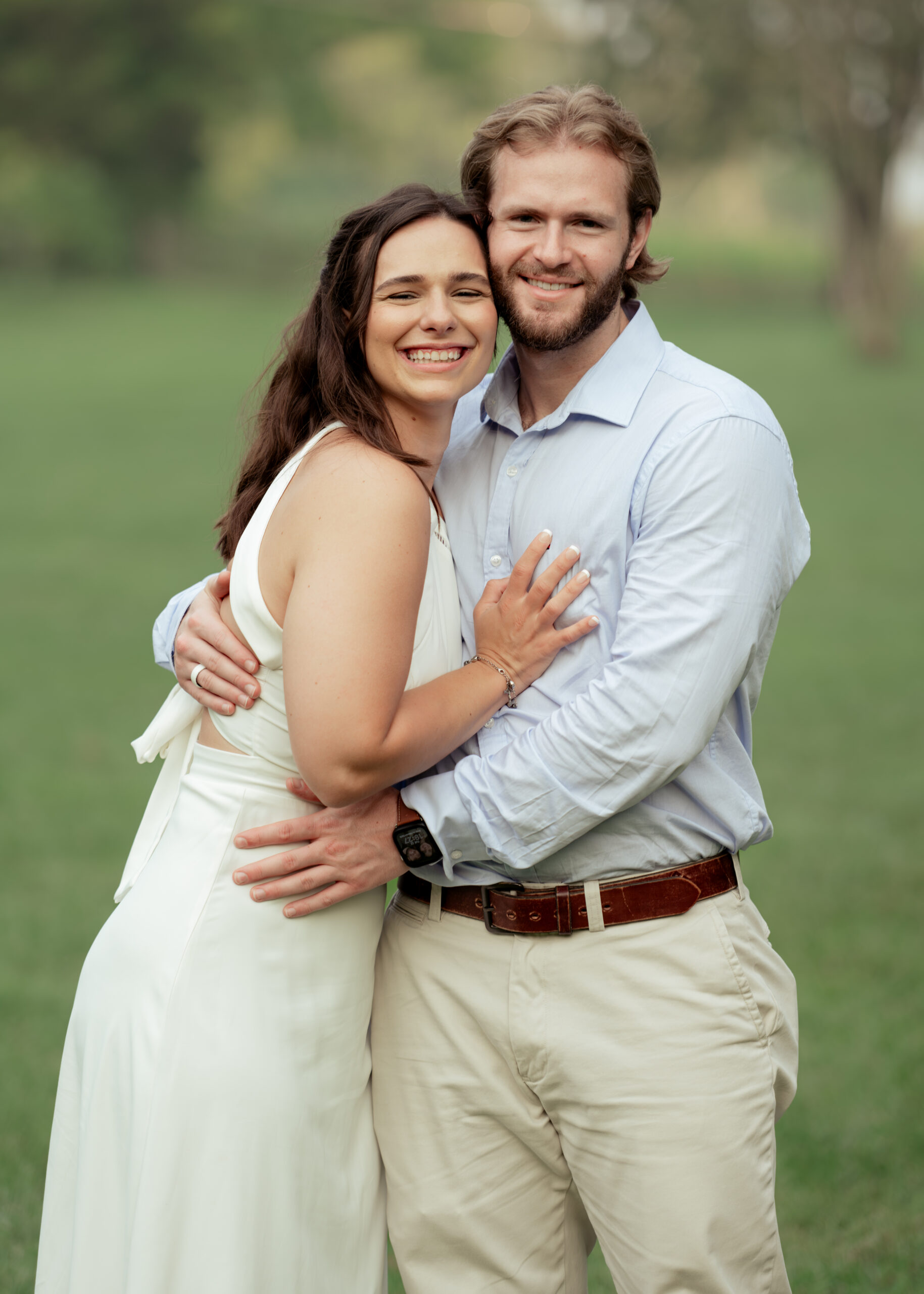 A catholic couple smiles authentically at the camera at the end of their effortless and fun engagement session in thompson's station, tn