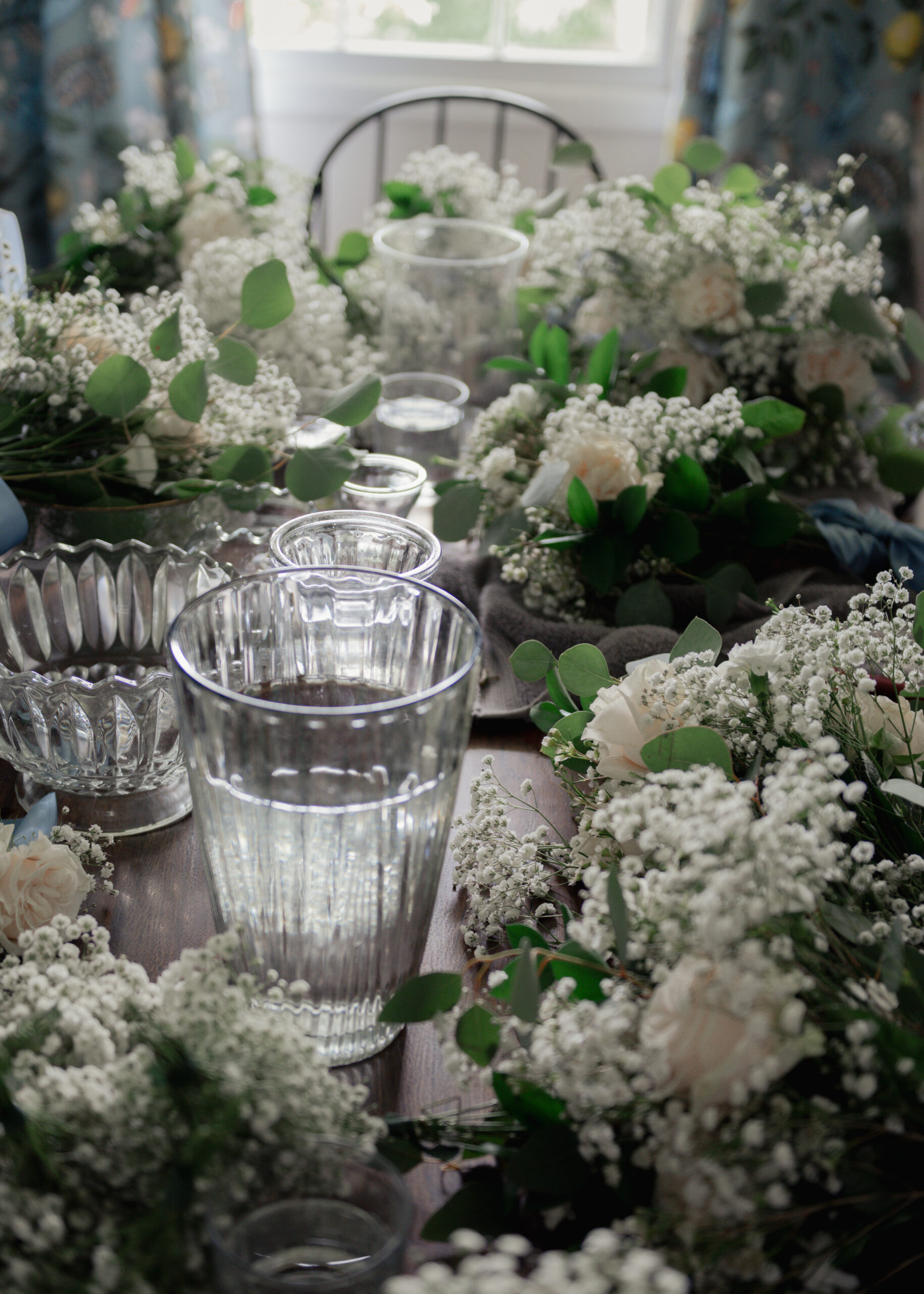 Flowers sit on a table in this candid detail image of wedding preparations for a catholic wedding in huntsville, alabama