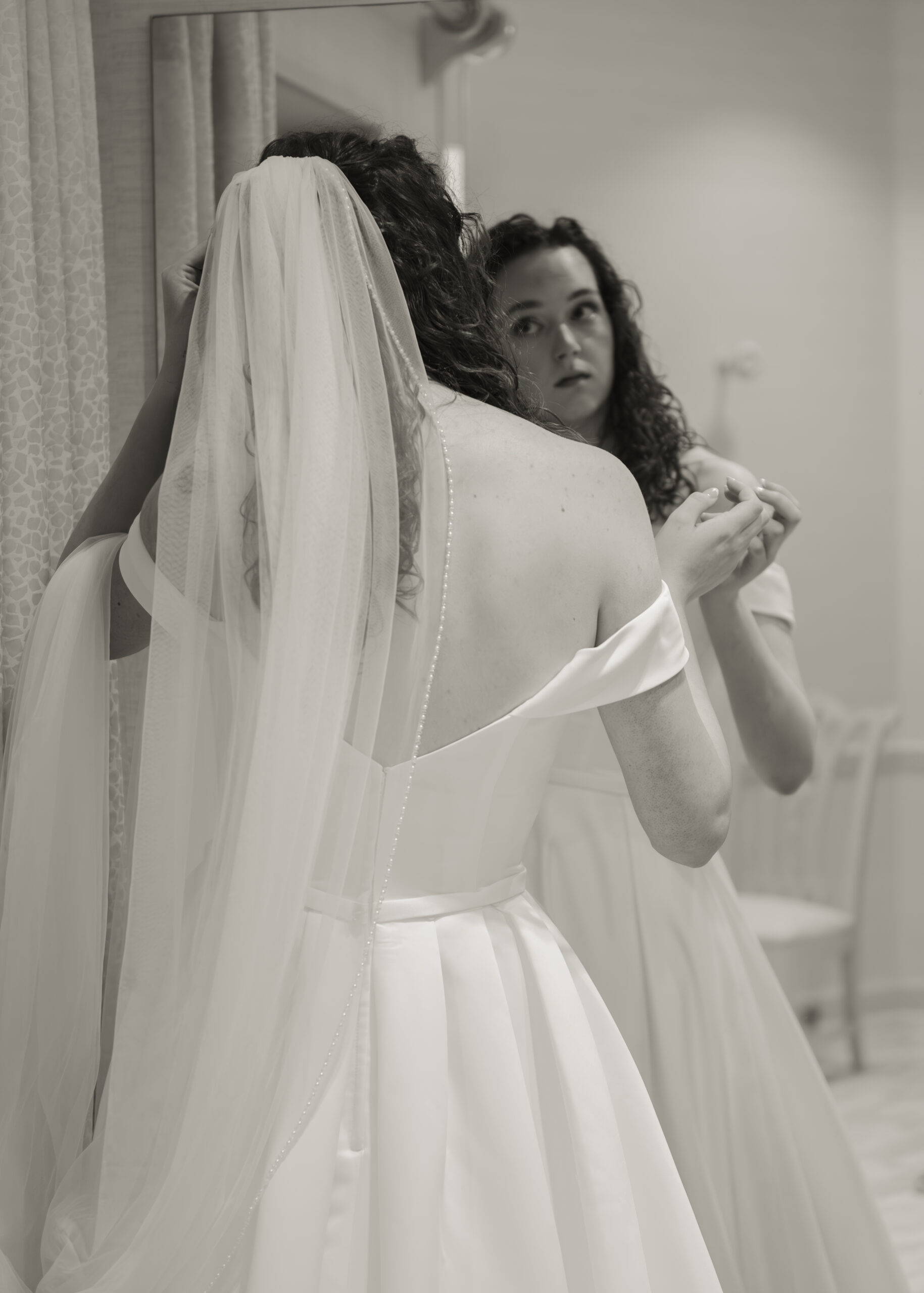 A bride adjusts her hair in the bridal suite of holy spirit catholic church in huntsville, al