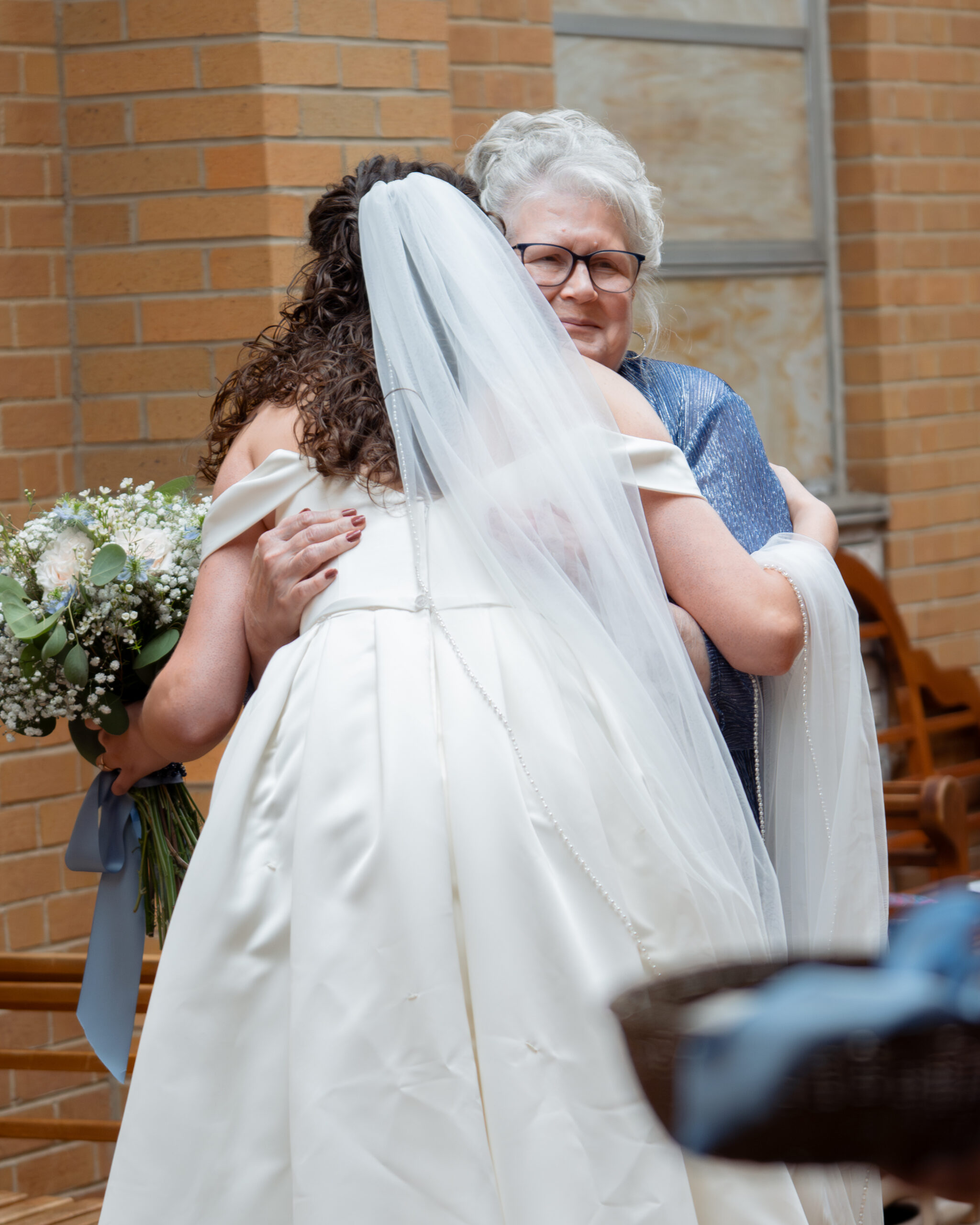 a bride gives her grandmother a tearful hug after showing her her wedding dress ahead of her huntsville catholic wedding day
